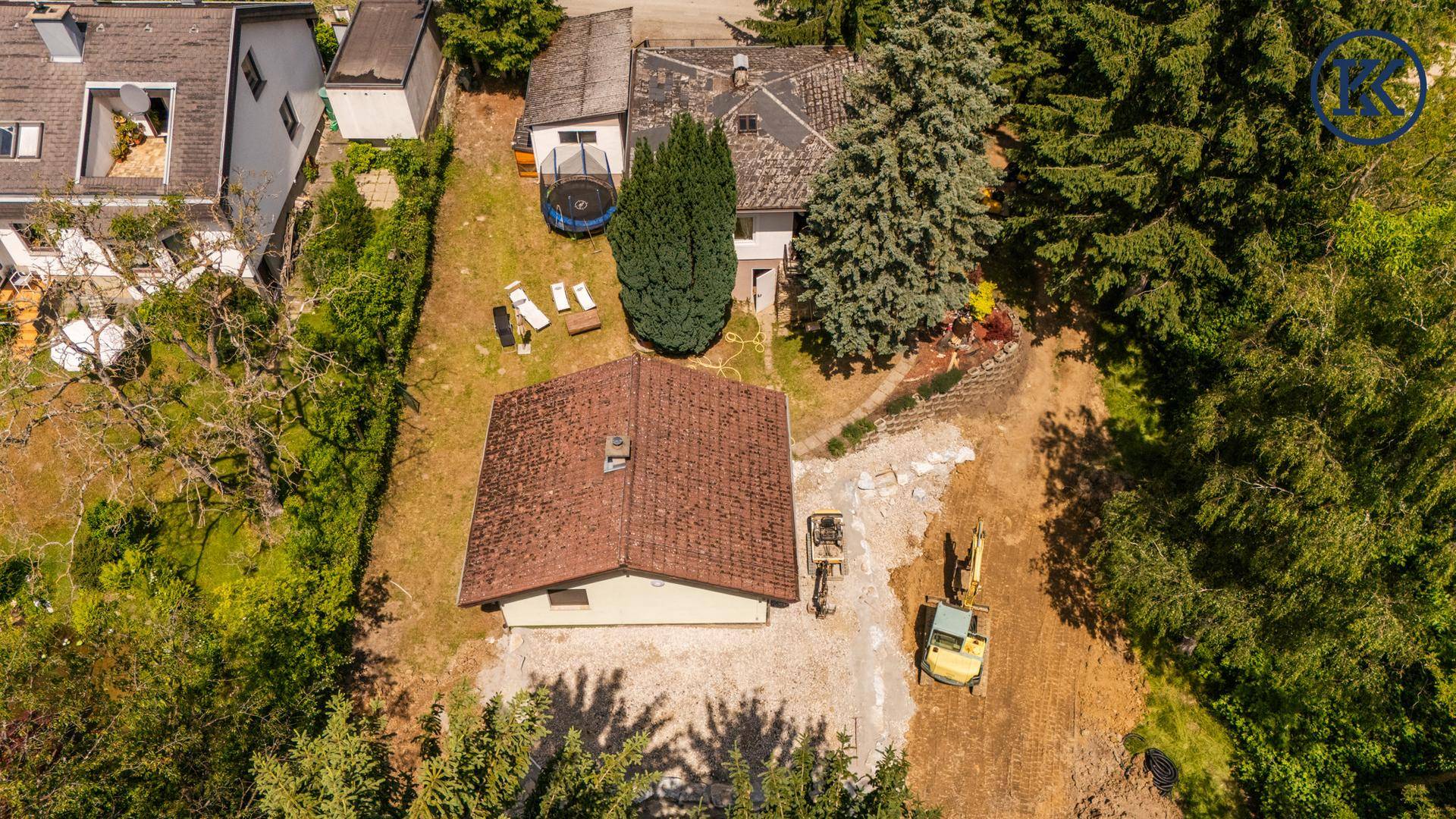 Ansicht des Anwesens von oben mit zwei Häusern, Garten und Bauarbeiten im Hintergrund.