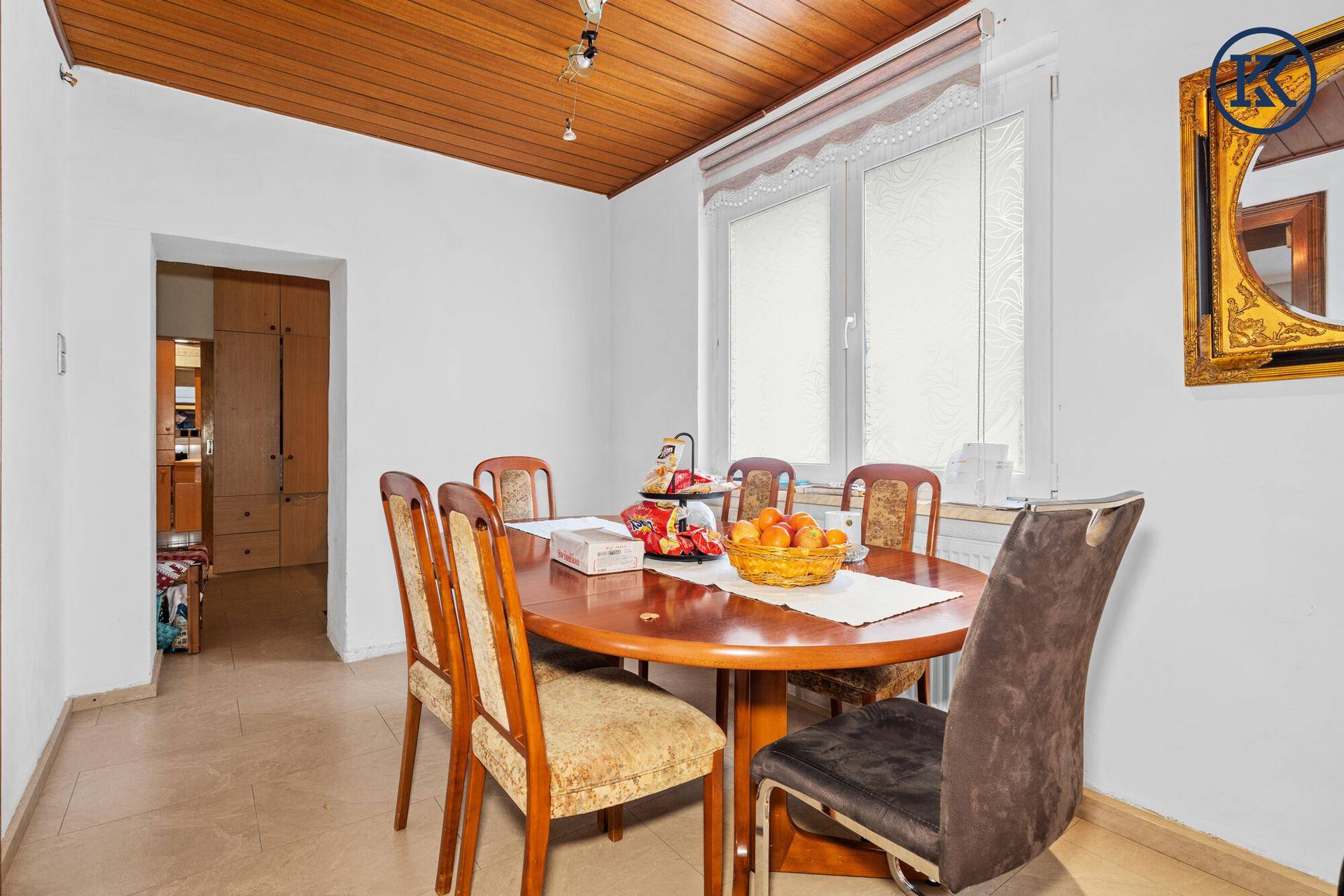 Gemütlicher Essbereich mit Holztisch, Stühlen und einer Holzdecke, ideal für Familienmahlzeiten.