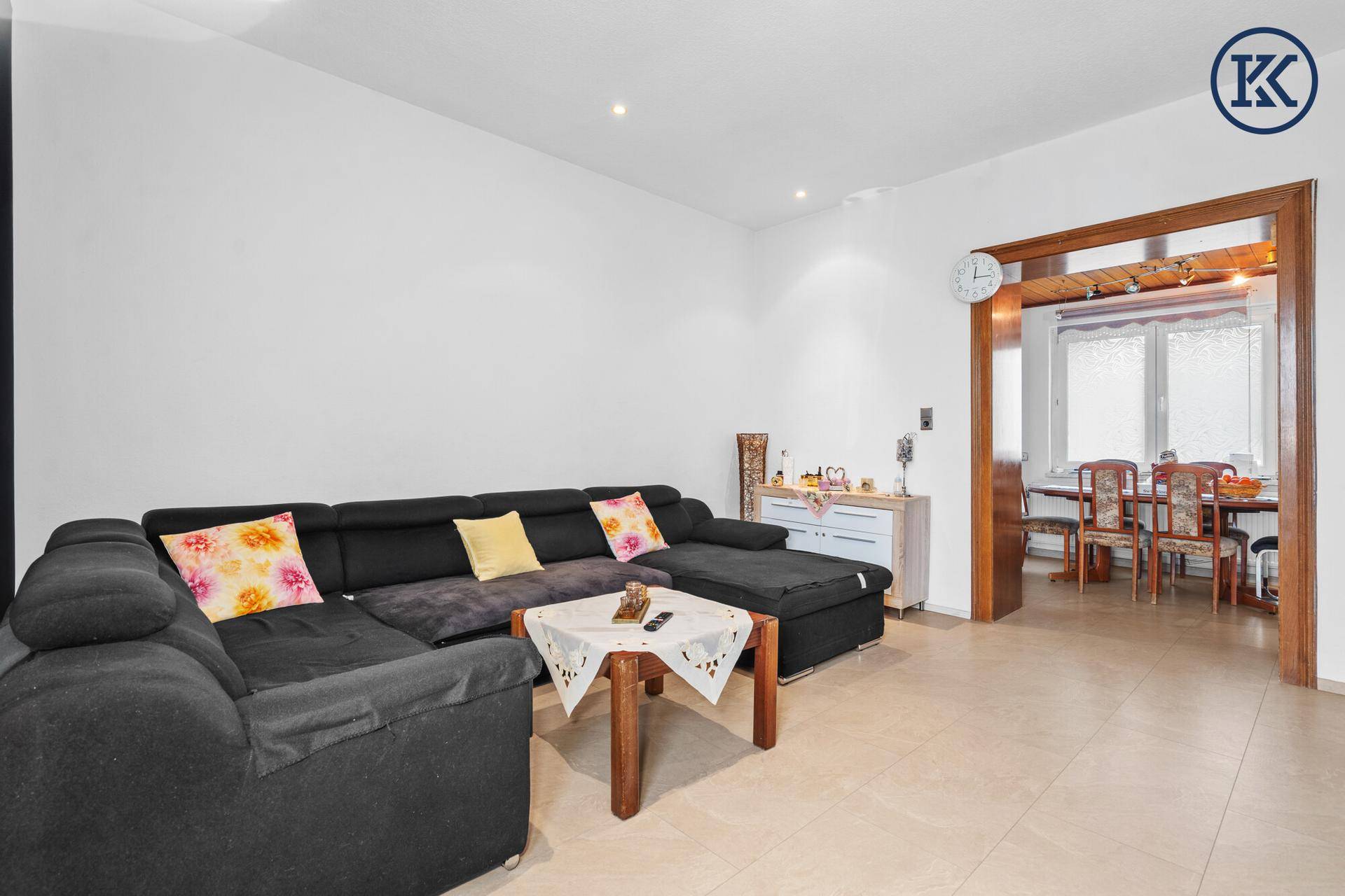 Wohnzimmer mit großem Ecksofa und offenem Zugang zum Essbereich.