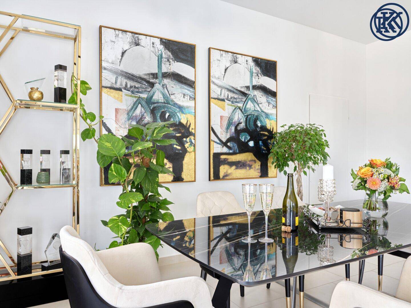 Konferenzraum mit Kunstwerken, Pflanzen und einem elegant gedeckten schwarzen Marmortisch.