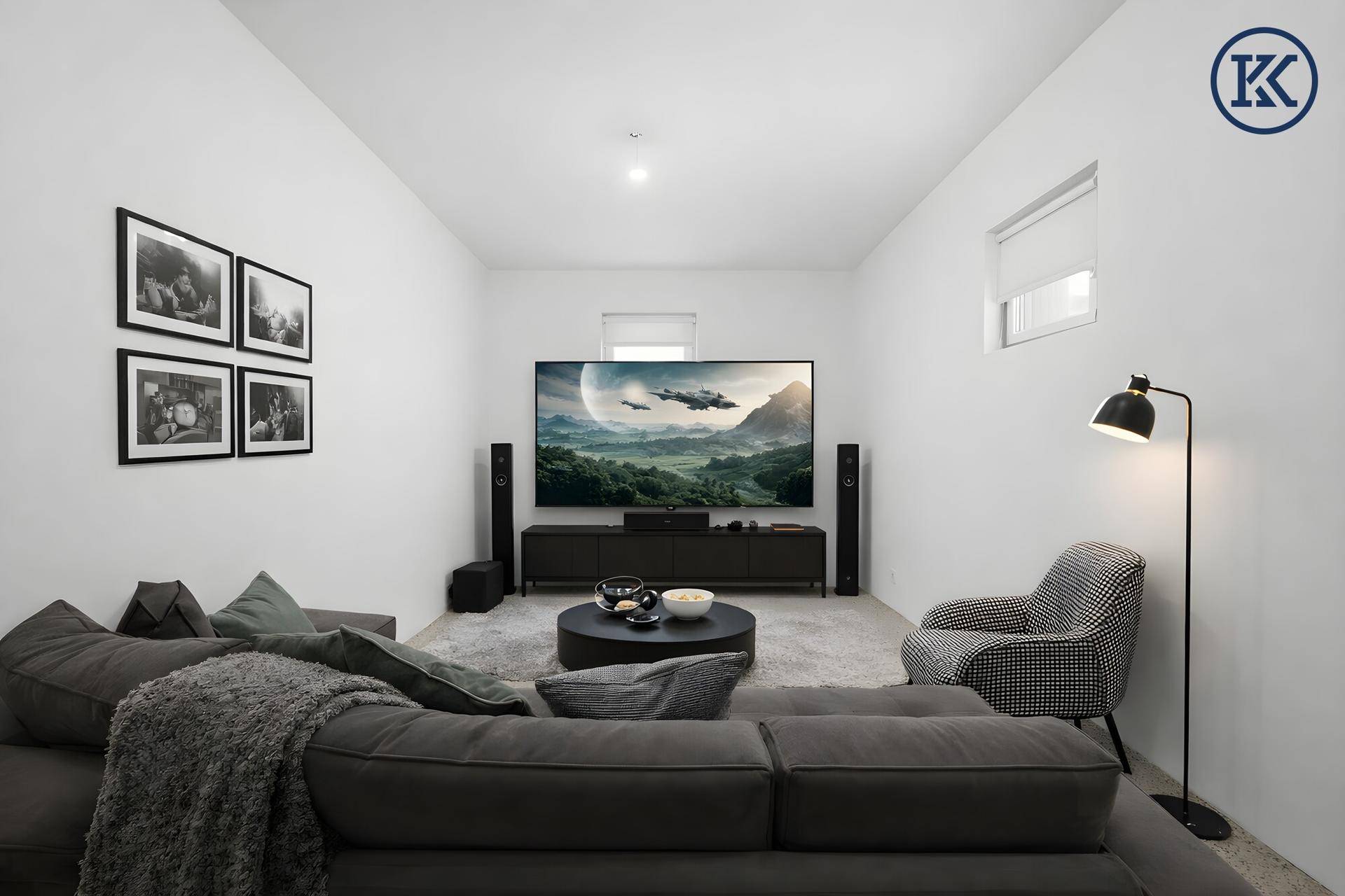 Gemütlicher Medienraum mit großem Bildschirm, bequemer Couch und moderner Einrichtung.