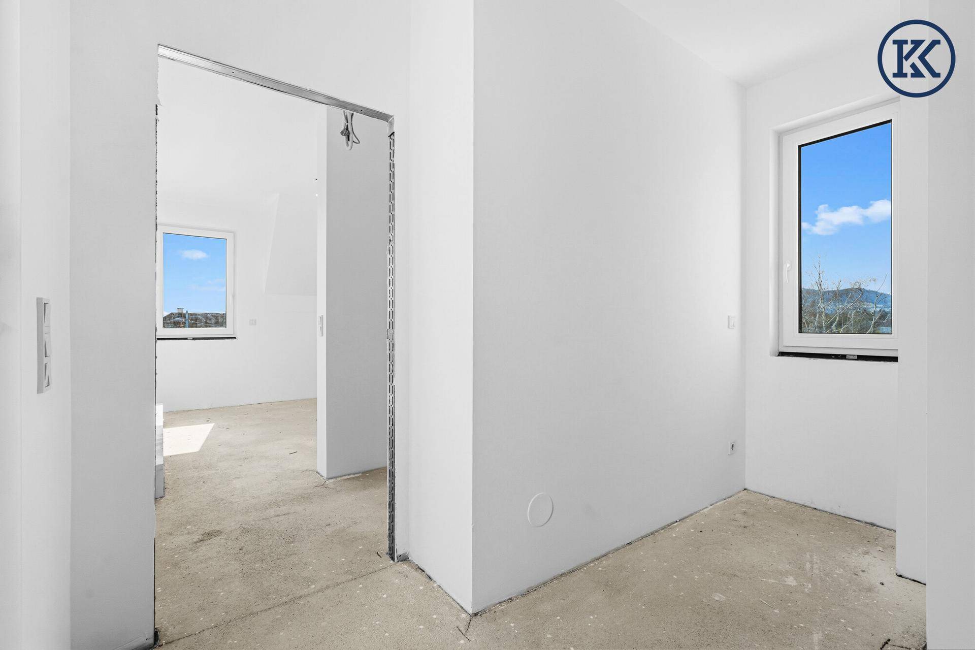 Heller Raum im Rohbau mit Fenster und Türöffnung, bereit für die individuelle Gestaltung.