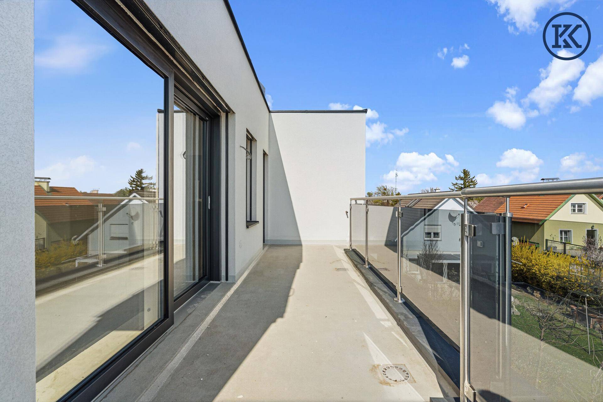 Langer Balkon mit Glasgeländer und Blick auf die Umgebung, ideal zum Entspannen.