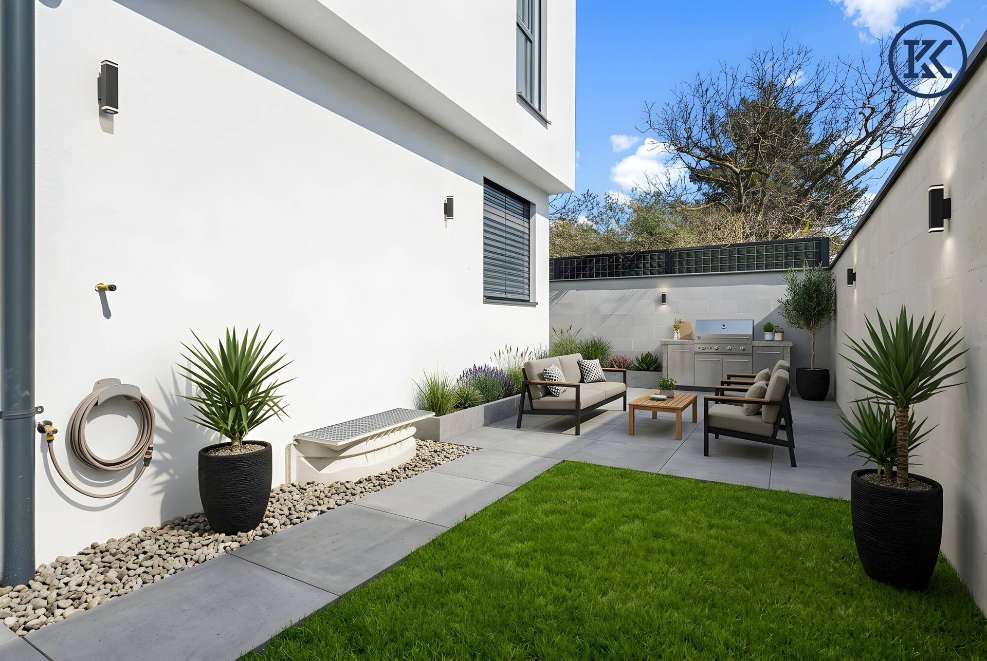 Gepflegter Gartenbereich mit Rasenfläche, Sitzgelegenheiten und Grillplatz, ideal für den Sommer.