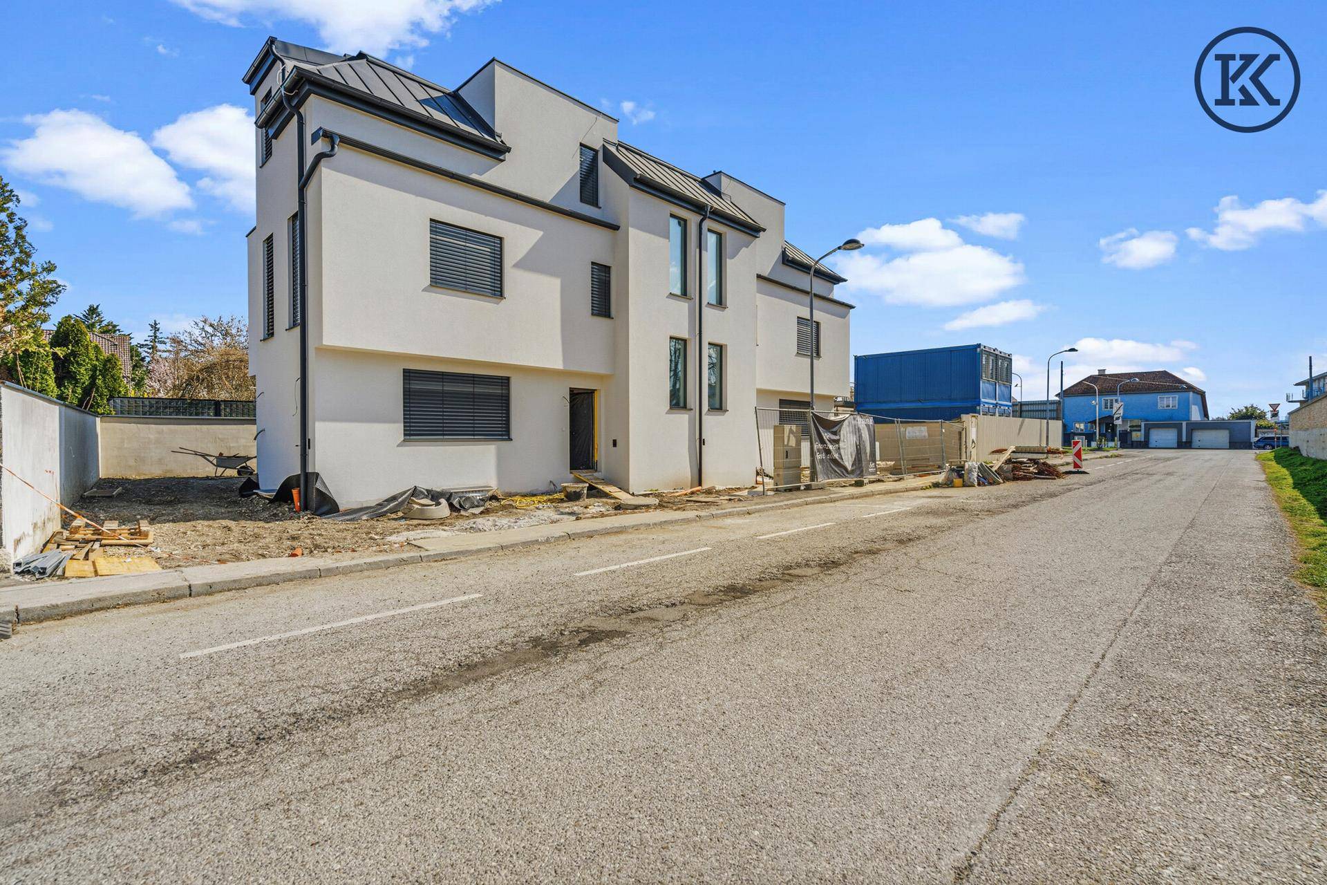 Seitenansicht der modernen Doppelhaushälfte von der Straße aus, noch im Bau.