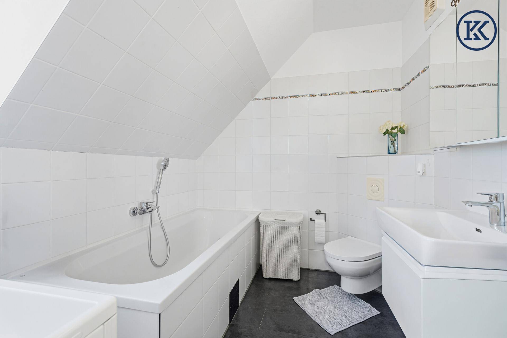 Helles Badezimmer im Dachgeschoss mit Badewanne, WC und Waschbecken.