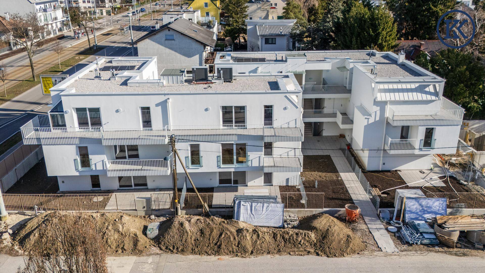 Gesamtansicht der modernen weißen Apartmentgebäude von oben mit umliegender Bebauung.