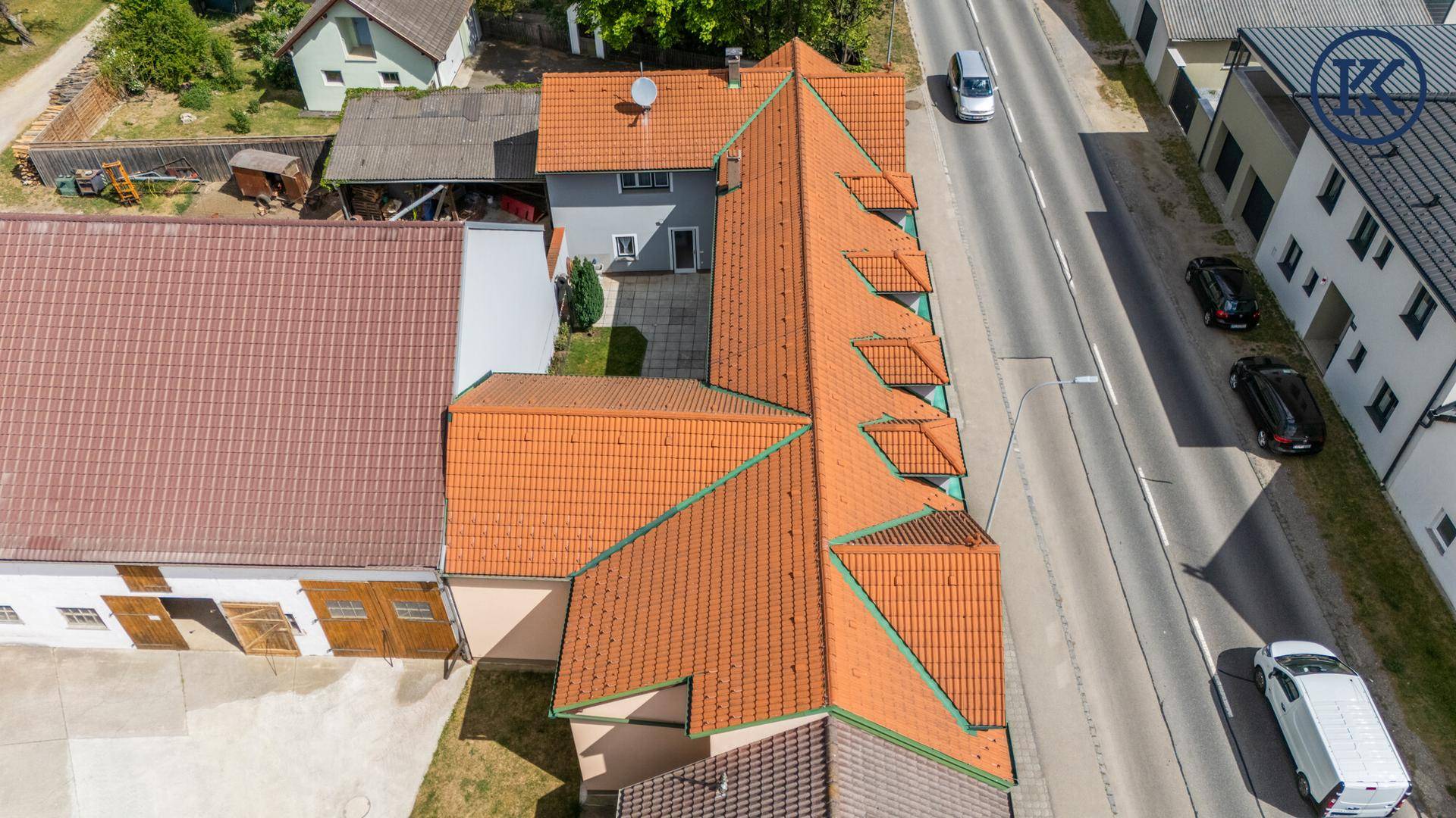 Vogelperspektive des Gebäudes mit rotem Ziegeldach und ländlicher Umgebung.