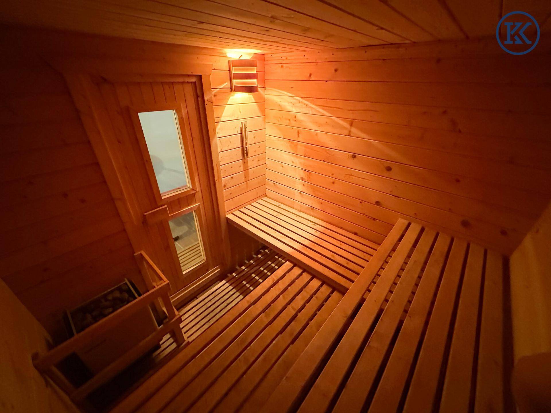 Gemütliche Holzsauna mit Bänken und Heizofen, bereit für entspannende Momente.
