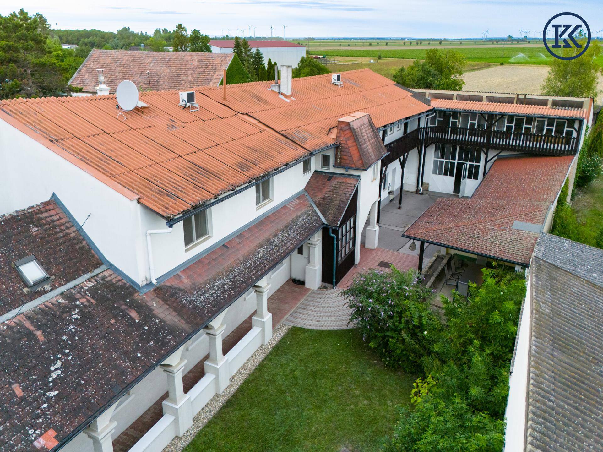 Weitläufiges Anwesen mit Innenhof, umgeben von grünen Feldern und ländlicher Umgebung.