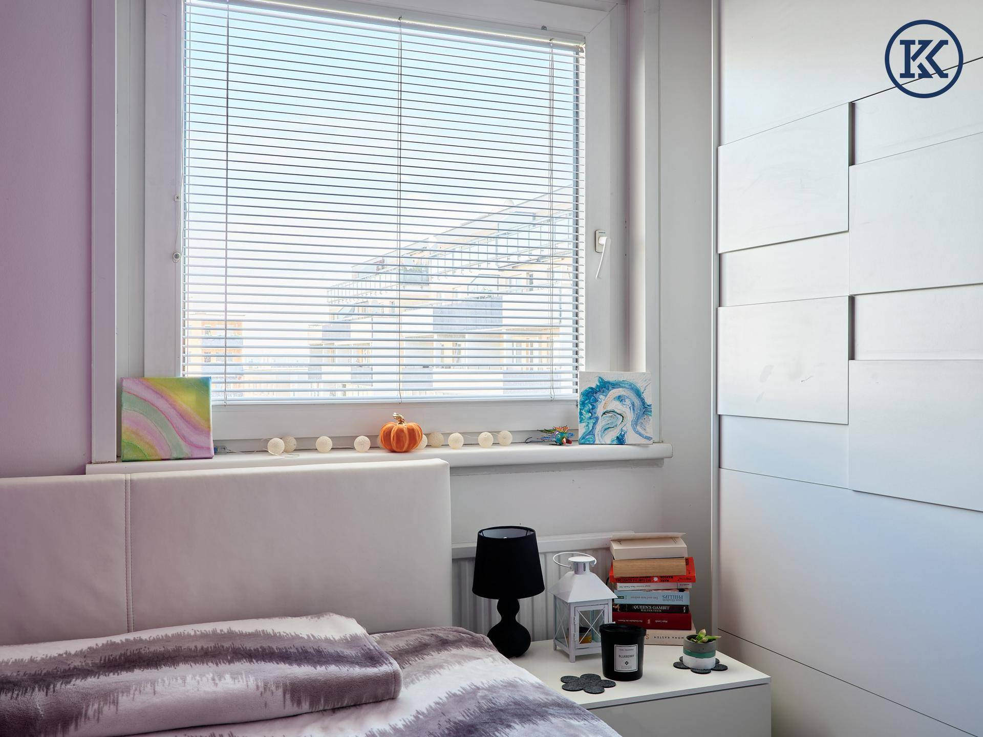 Fenster im Schlafzimmer mit Blick nach draußen und dekorativen Elementen.