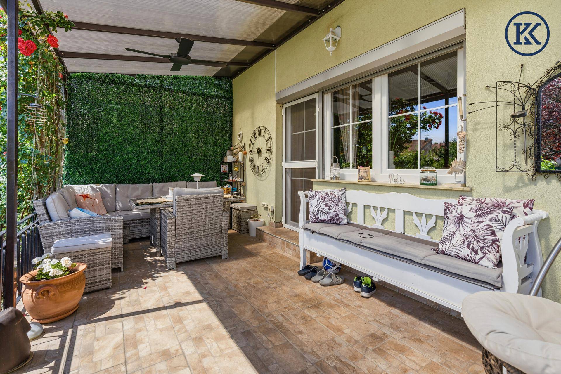 Überdachte Terrasse mit bequemen Gartenmöbeln und Blick ins Grüne.