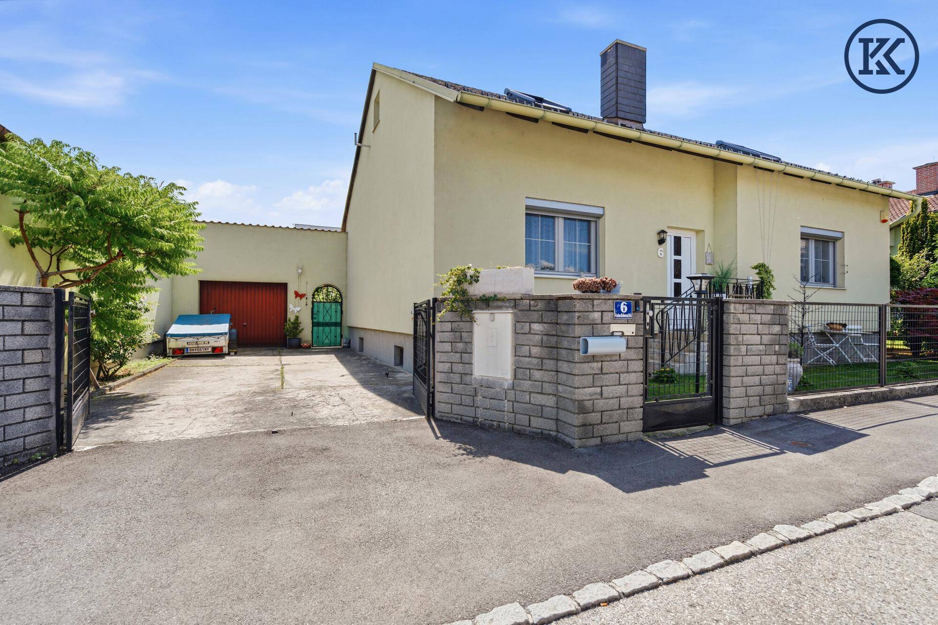 Vorderansicht des Hauses mit Einfahrt, Garage und gepflegtem Vorgartenbereich.