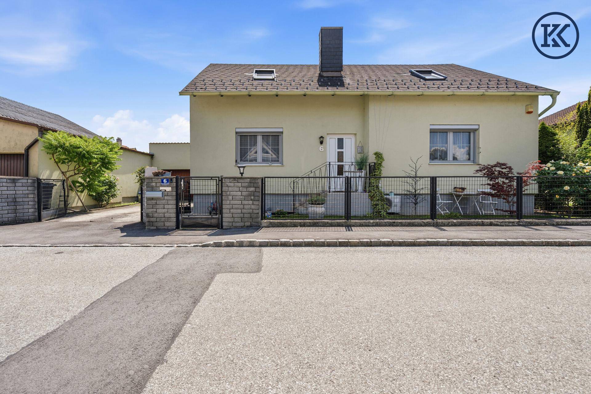 Gesamtansicht des Einfamilienhauses von der Straße mit Vorgarten und Zufahrt zur Garage.
