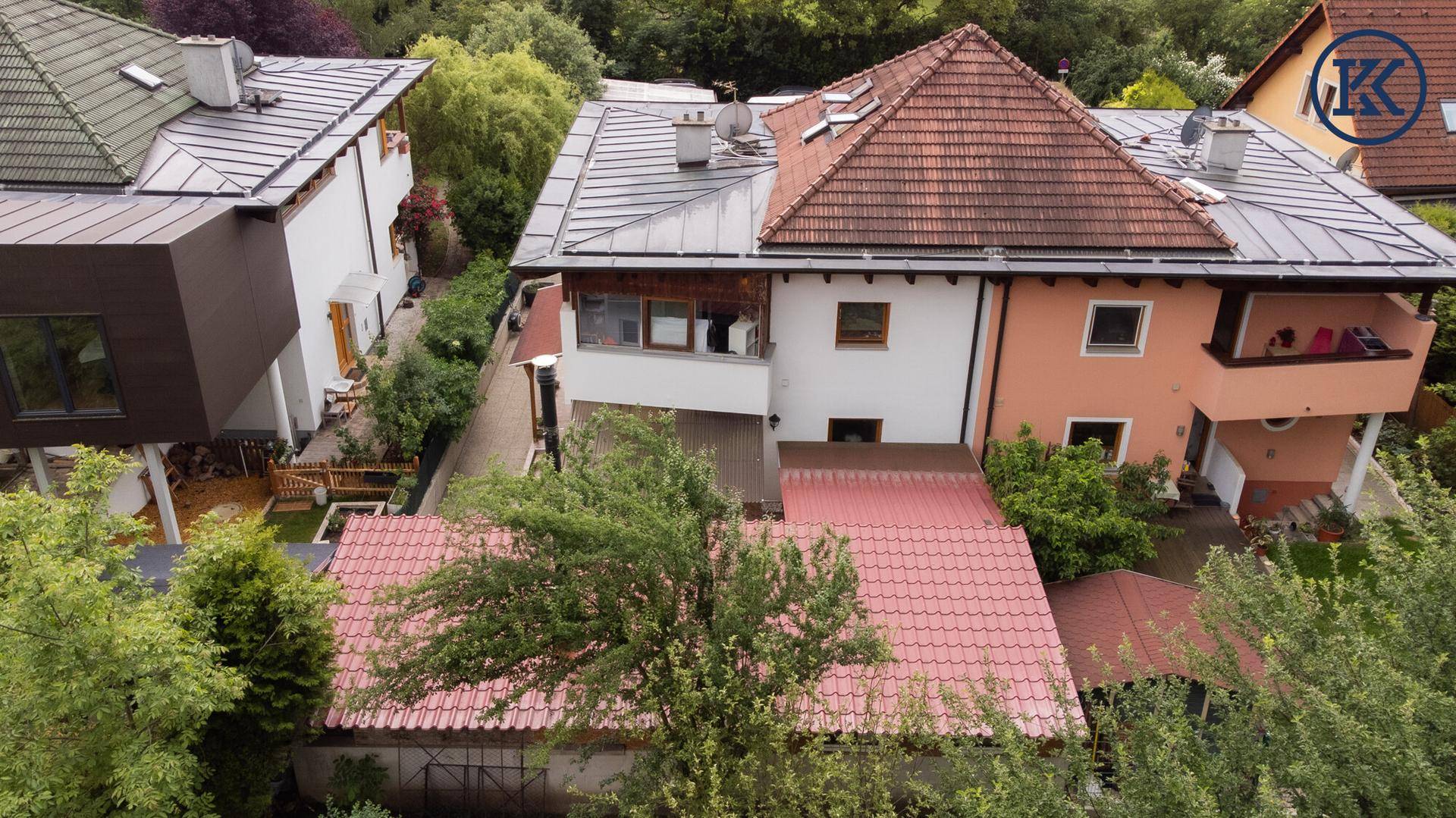 Seitenansicht des Hauses von oben mit verschiedenen Dachtypen und umgebender dichter Vegetation.