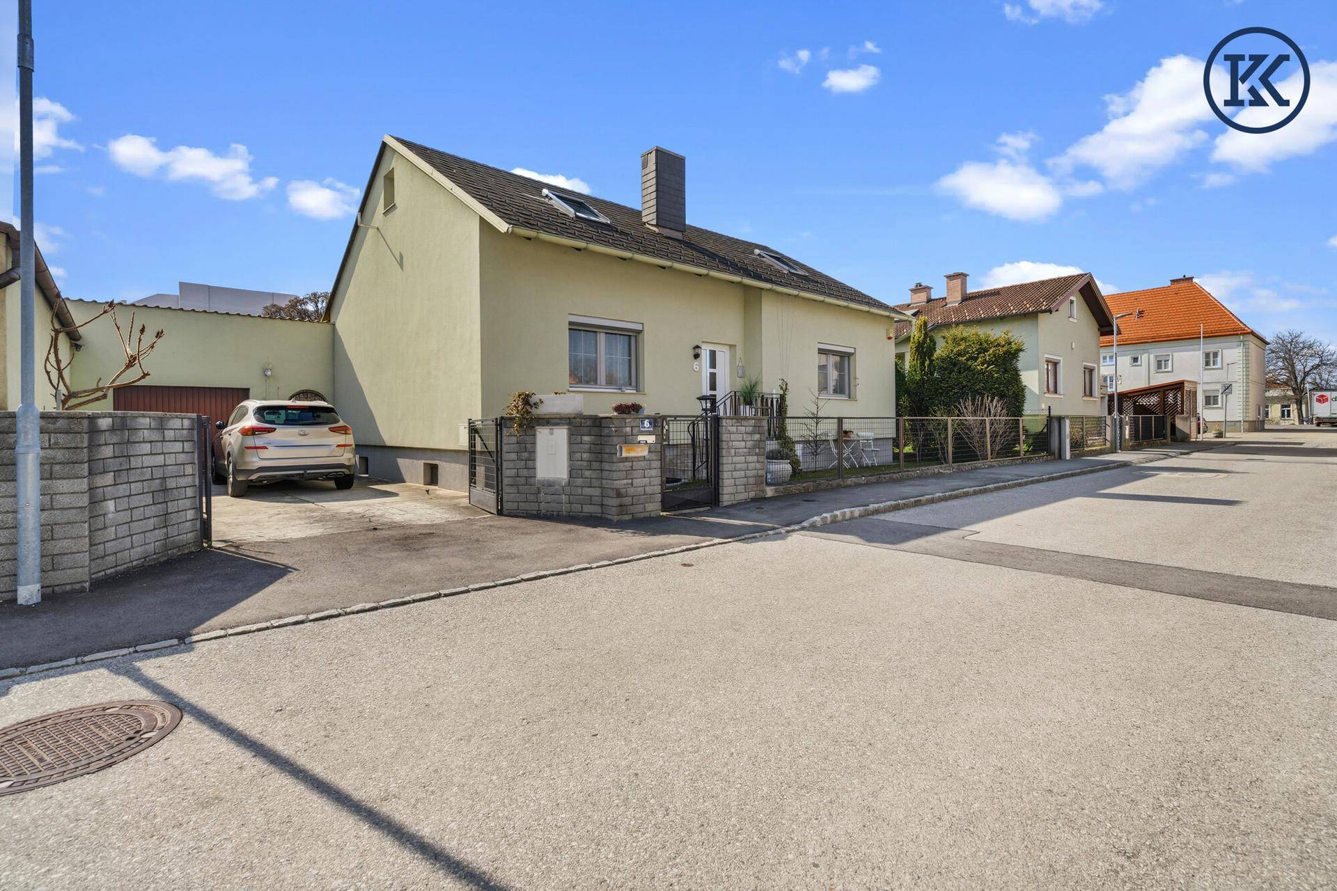 Ansicht des Hauses von der Straße mit Einfahrt und einem geparkten Auto.