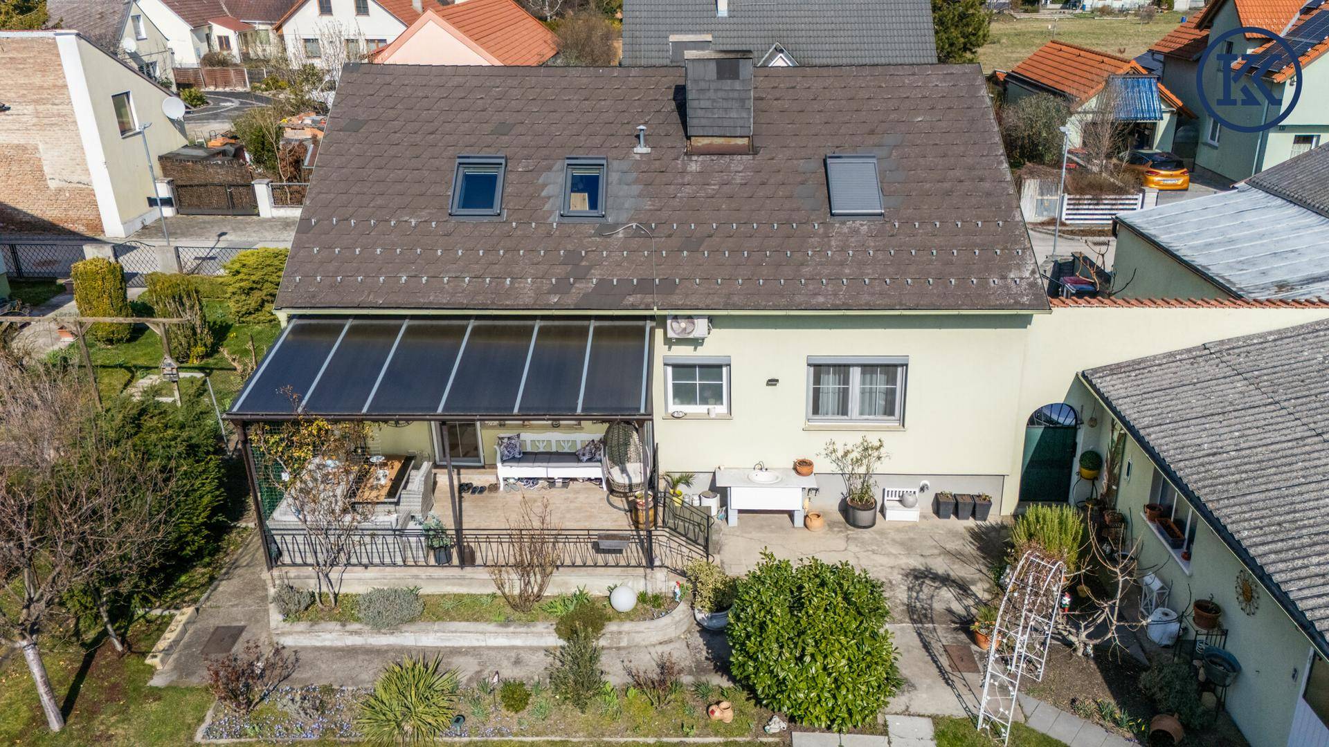 Luftaufnahme der Rückseite des Hauses mit überdachter Terrasse und Gartenbereich.