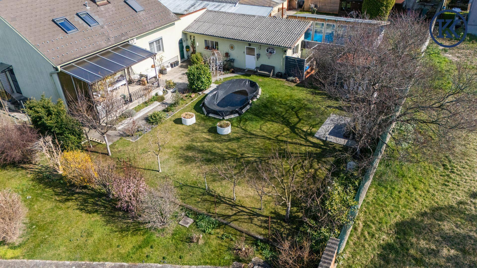 Luftaufnahme des Grundstücks mit Haus, Garten und angrenzenden Grünflächen.