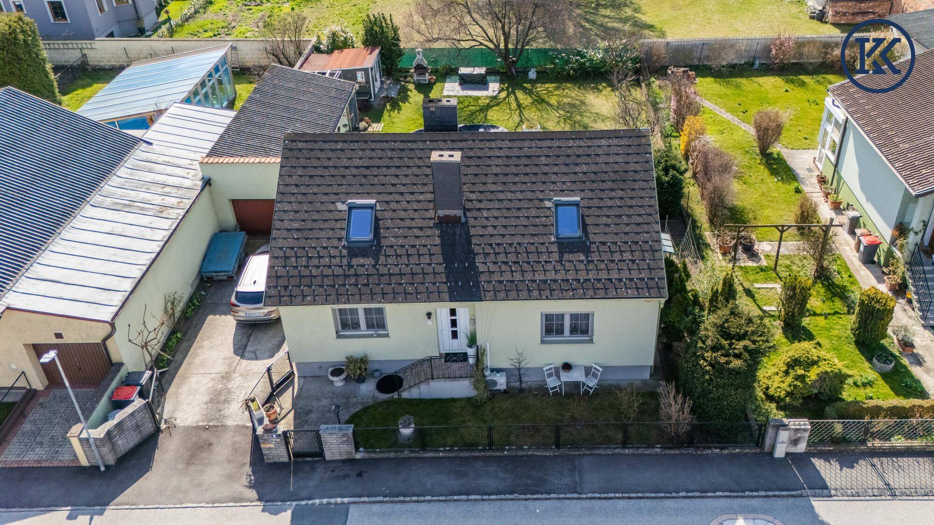 Luftaufnahme der Vorderseite des Hauses mit Vorgarten und Zufahrt.