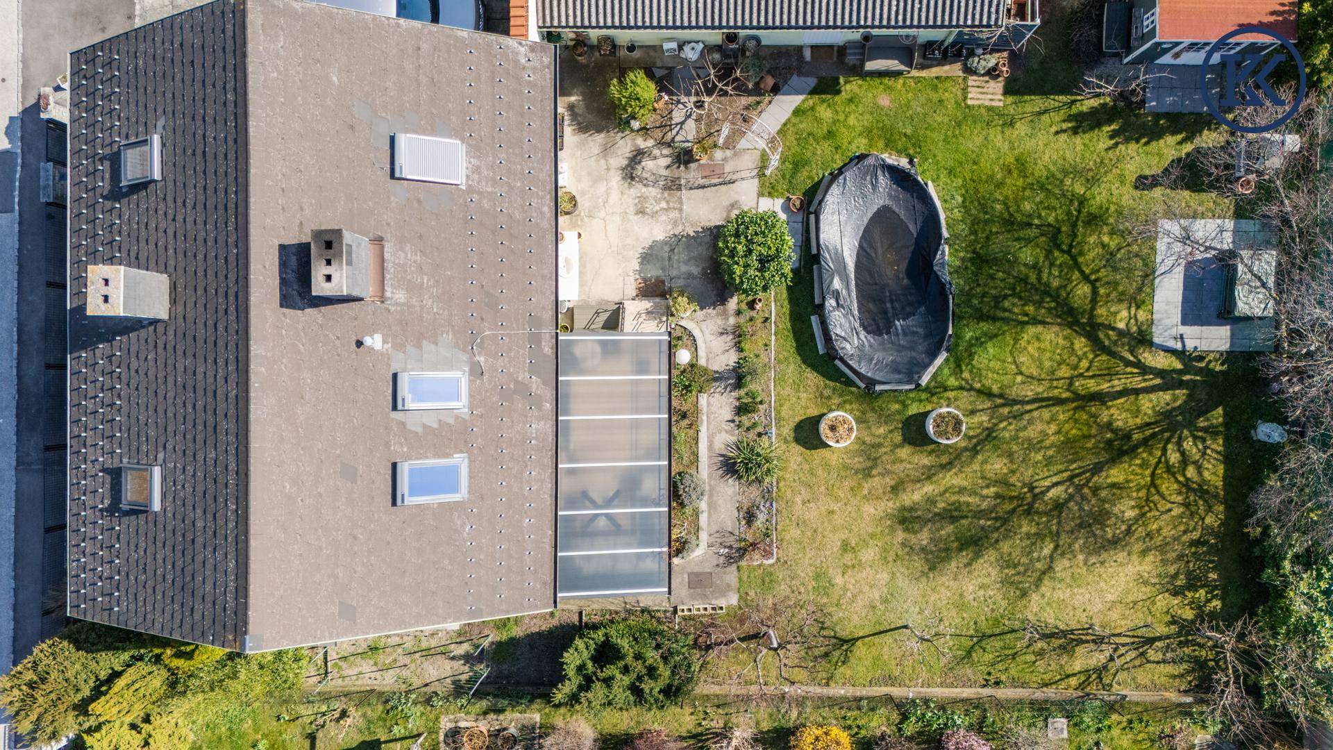 Draufsicht des Grundstücks mit Haus, großem Garten und Poolbereich.