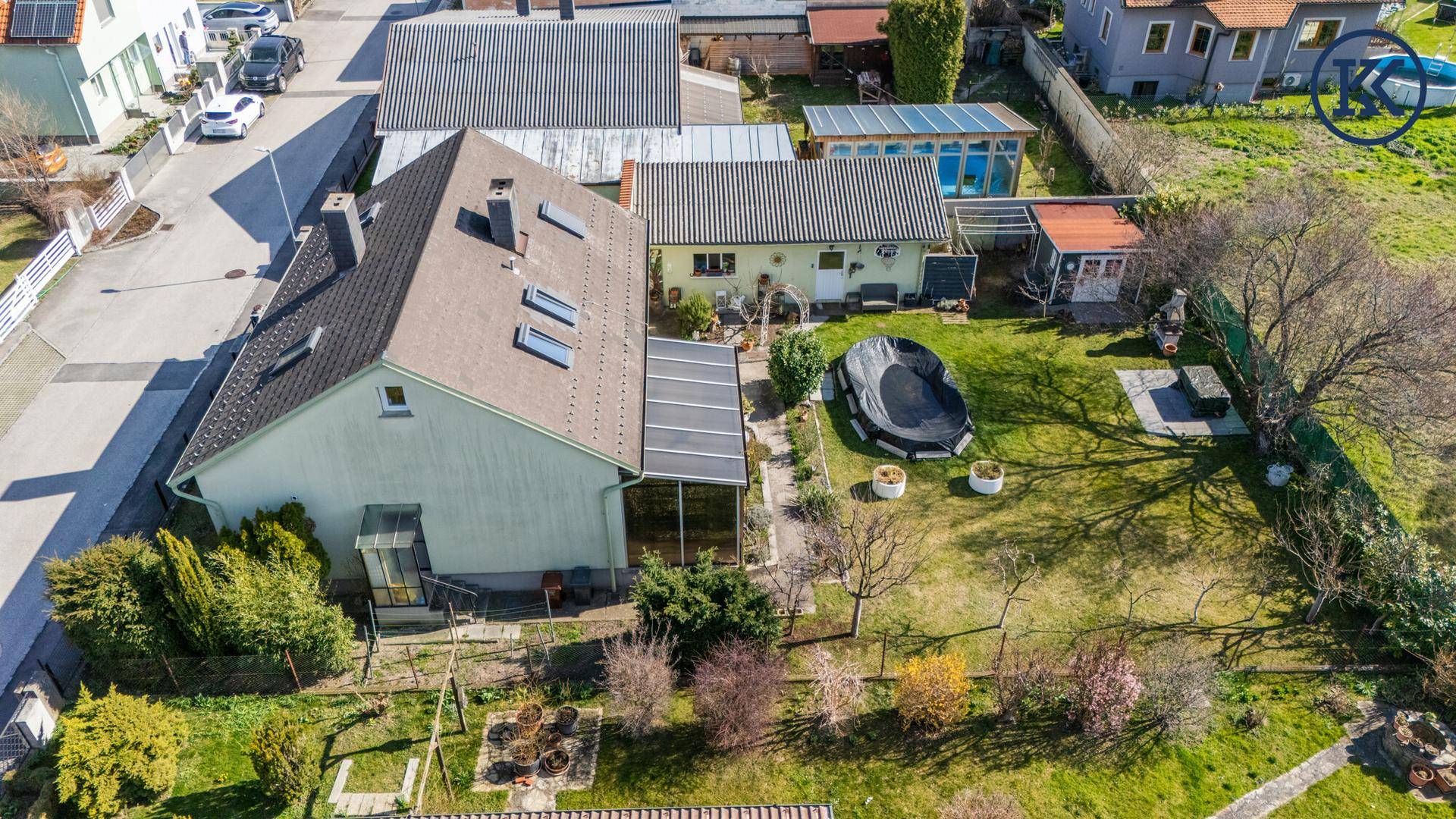 Luftaufnahme des Grundstücks mit Haus, Garten und umliegender Bebauung.