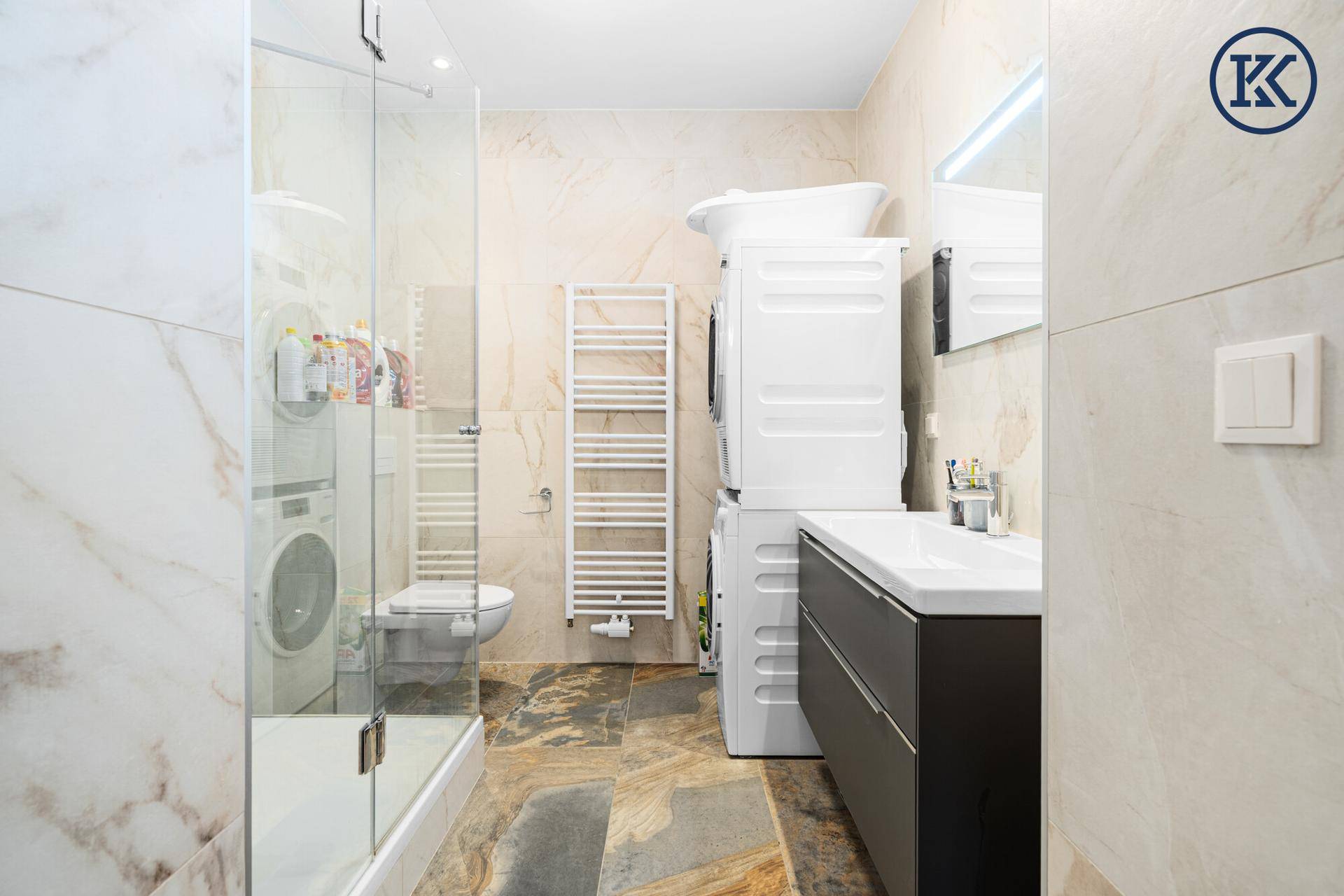 Modernes Badezimmer mit begehbarer Dusche, Waschmaschine und Trockner.