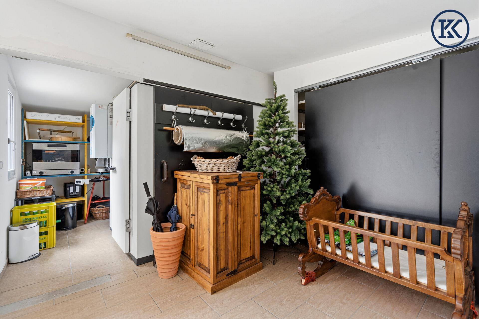 Vielseitiger Raum mit Lagerregalen, einem Kinderbett und einem Weihnachtsbaum.