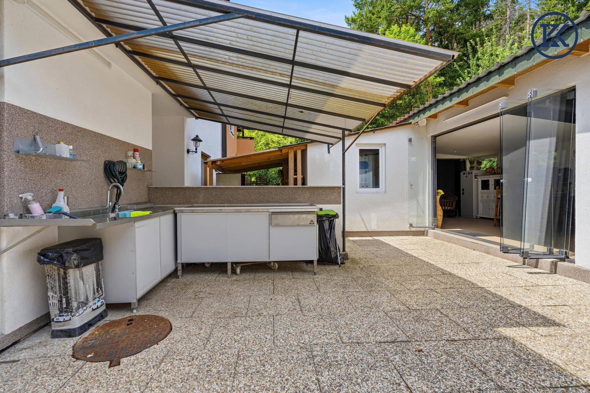 Überdachte Außenküche mit Spülbecken und viel Platz für gesellige Stunden.