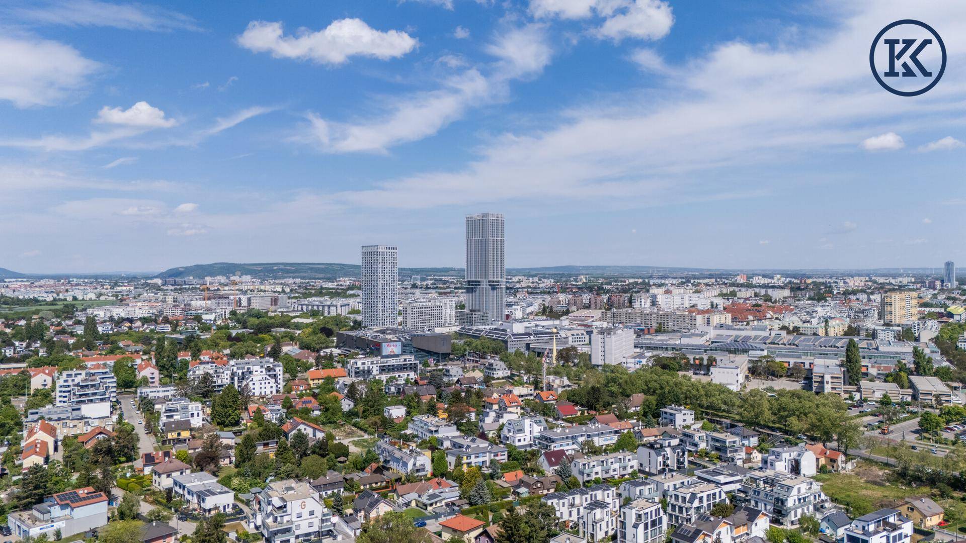 Weitläufiger Stadtblick mit Wohngebieten und modernen Hochhäusern am Horizont.