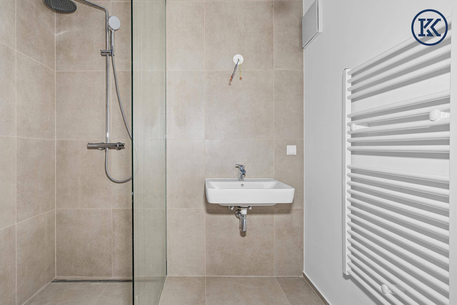 Modernes Badezimmer mit begehbarer Dusche, Einzelwaschbecken und beheiztem Handtuchhalter.