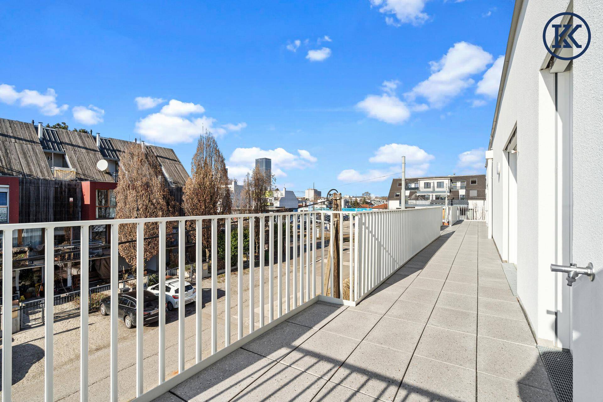 Geräumiger Balkon mit Fliesenboden und weitem Blick über die Umgebung und die Stadt.