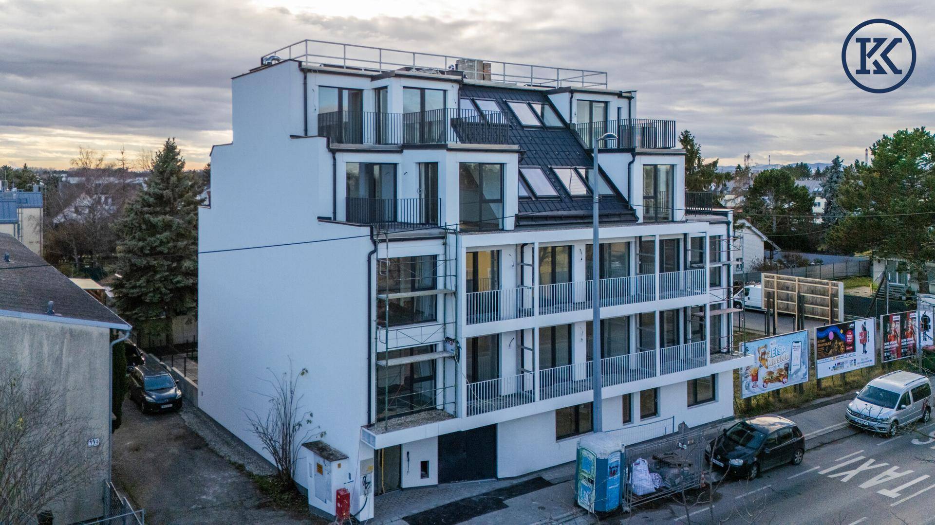 Neubau eines modernen Mehrfamilienhauses mit gestuften Balkonen und großen Fensterfronten.