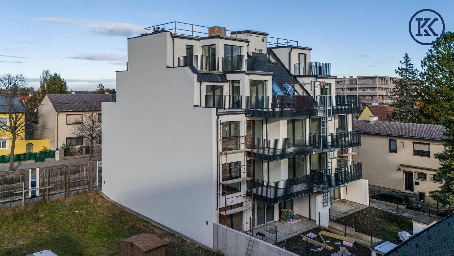 Seitenansicht eines modernen Wohngebäudes mit gestufter Architektur und zahlreichen Balkonen.