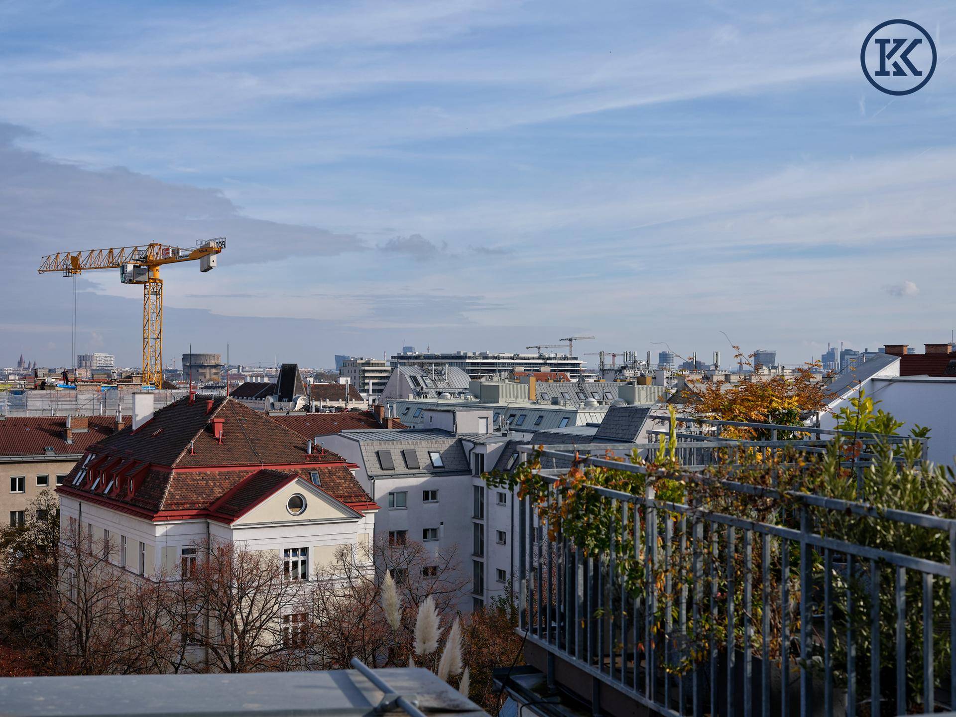 Weitläufiger Stadtblick mit einem Baukran und einer Mischung aus alten und neuen Gebäuden.