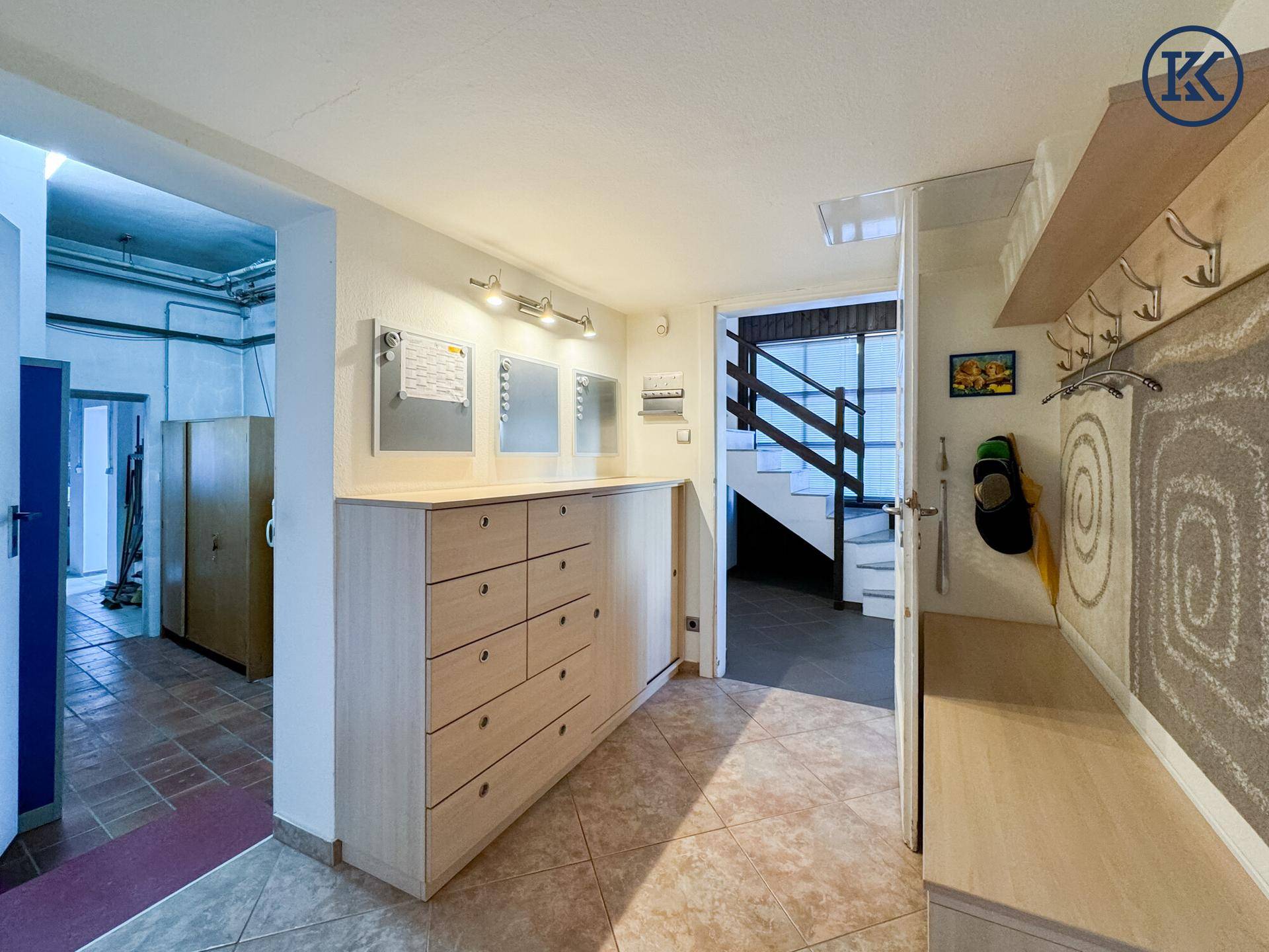 Heller Eingangsbereich mit Fliesenboden, Einbauschränken und Garderobe.
