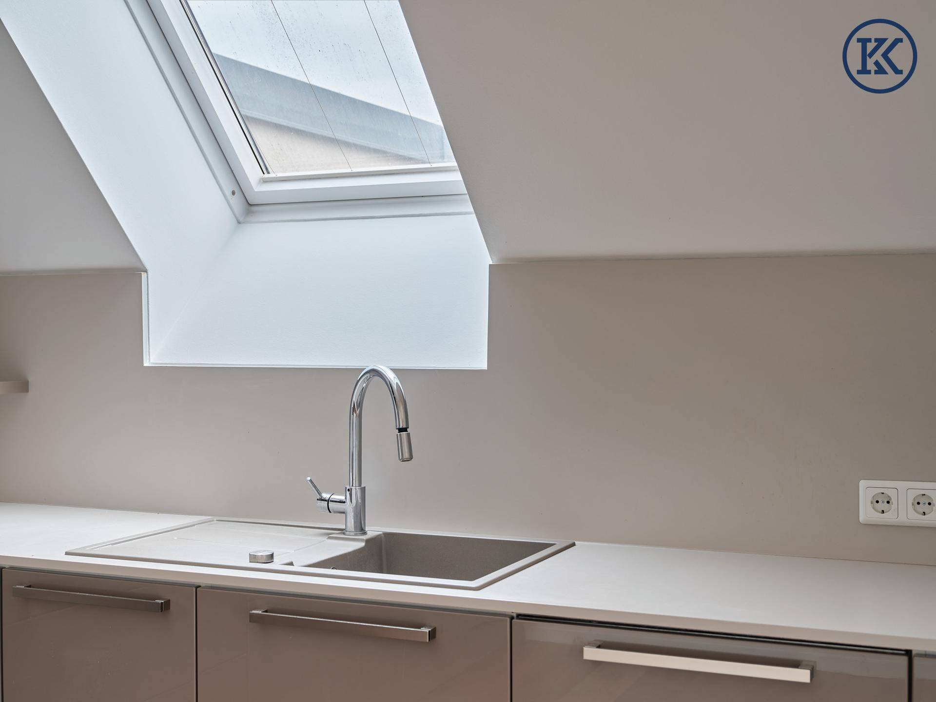 Detailansicht der modernen Küche mit Spüle, Armatur und Dachfenster.