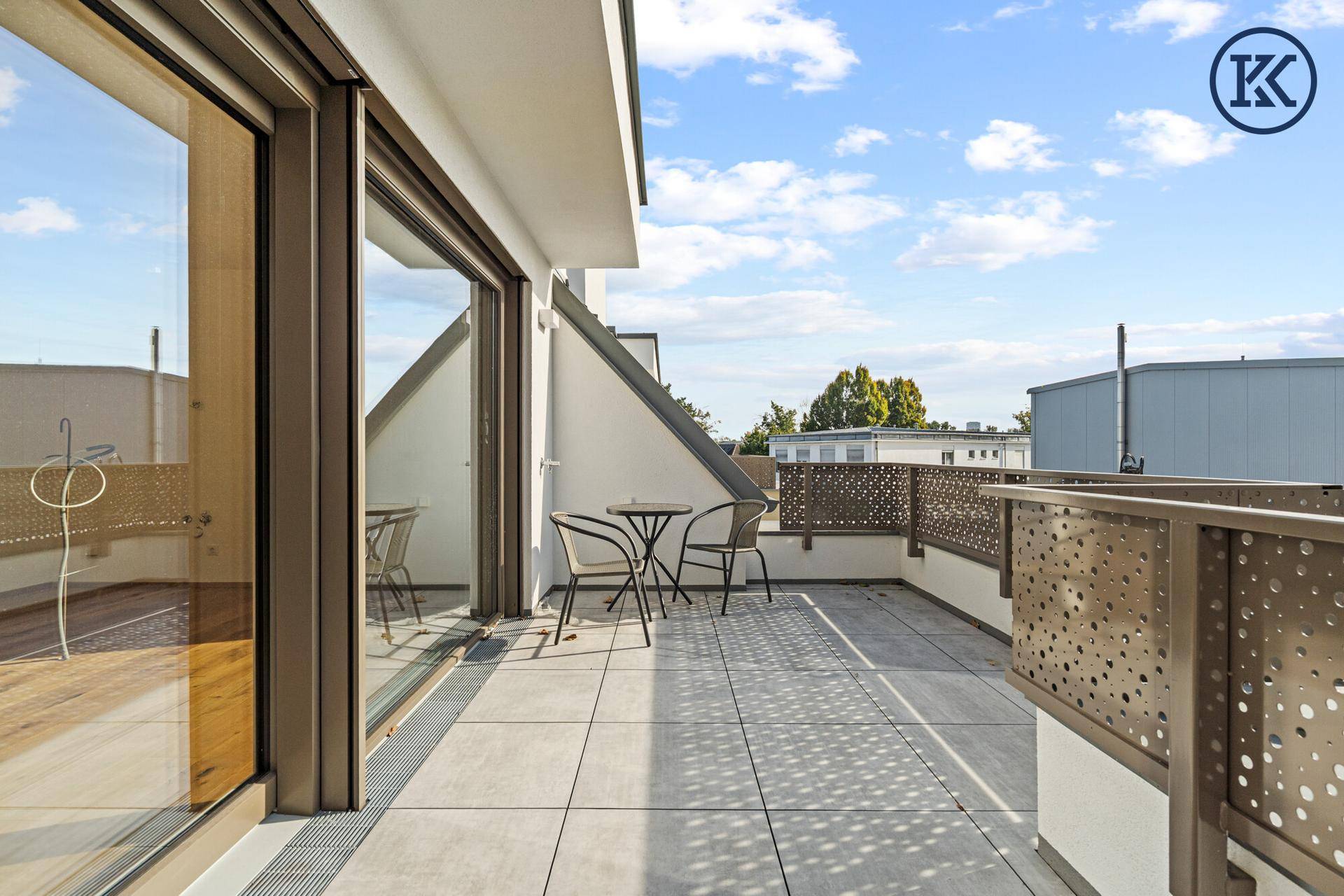 Helle Terrasse mit großen Glasschiebetüren und modernem Geländer, ideal für Entspannung im Freien.