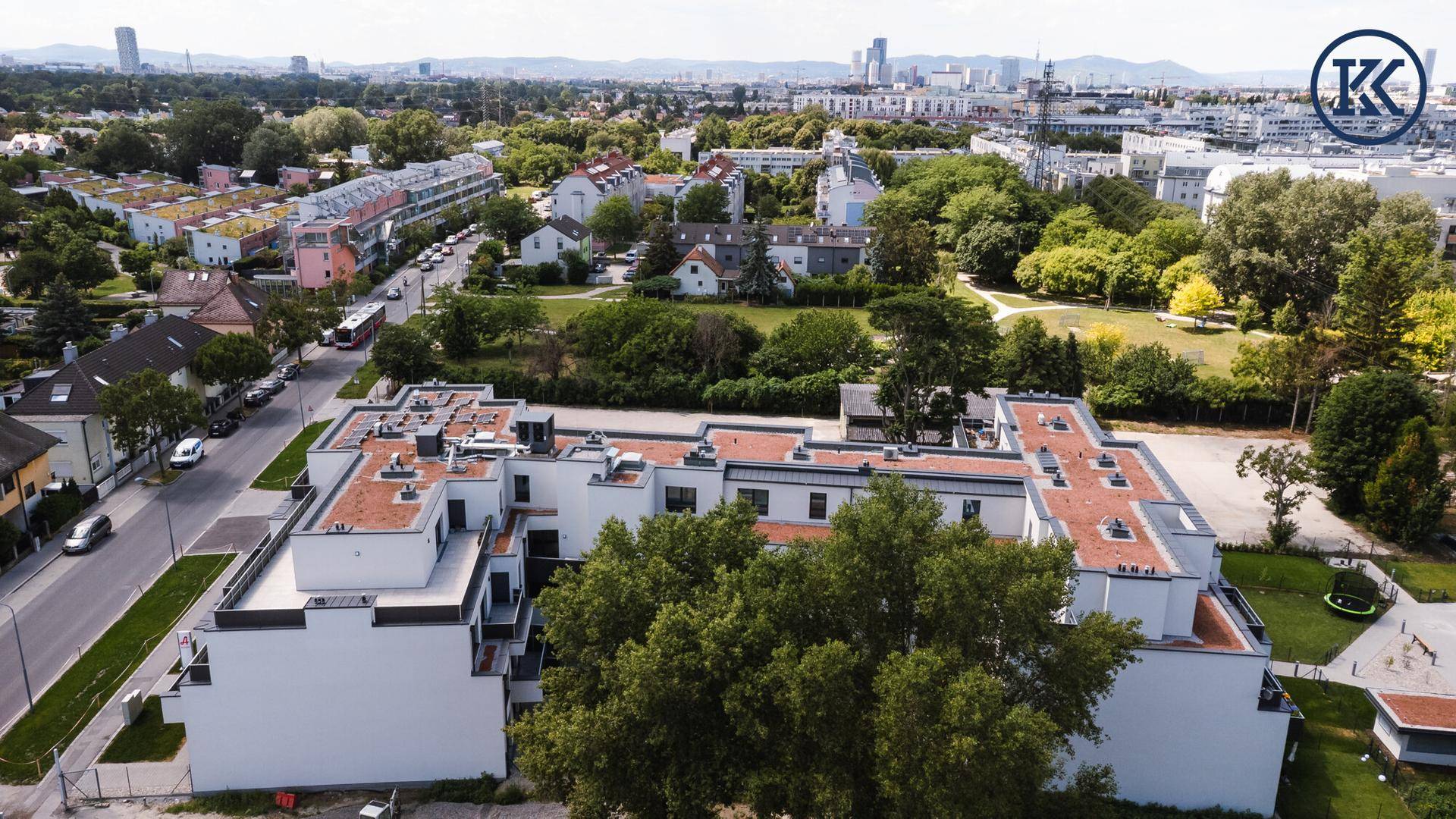 Moderne Wohnanlage mit Flachdacharchitektur und grüner Umgebung aus der Vogelperspektive.