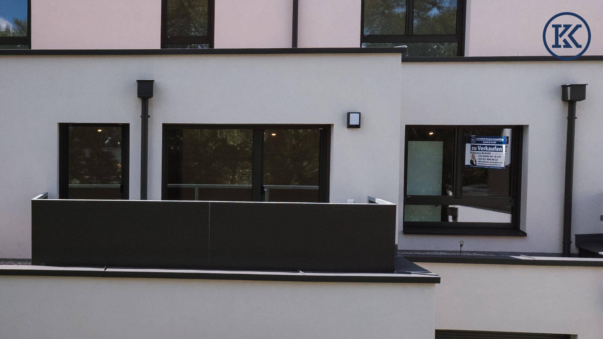 Balkon eines Apartments mit modernem Geländer und einem 'zu verkaufen'-Schild.