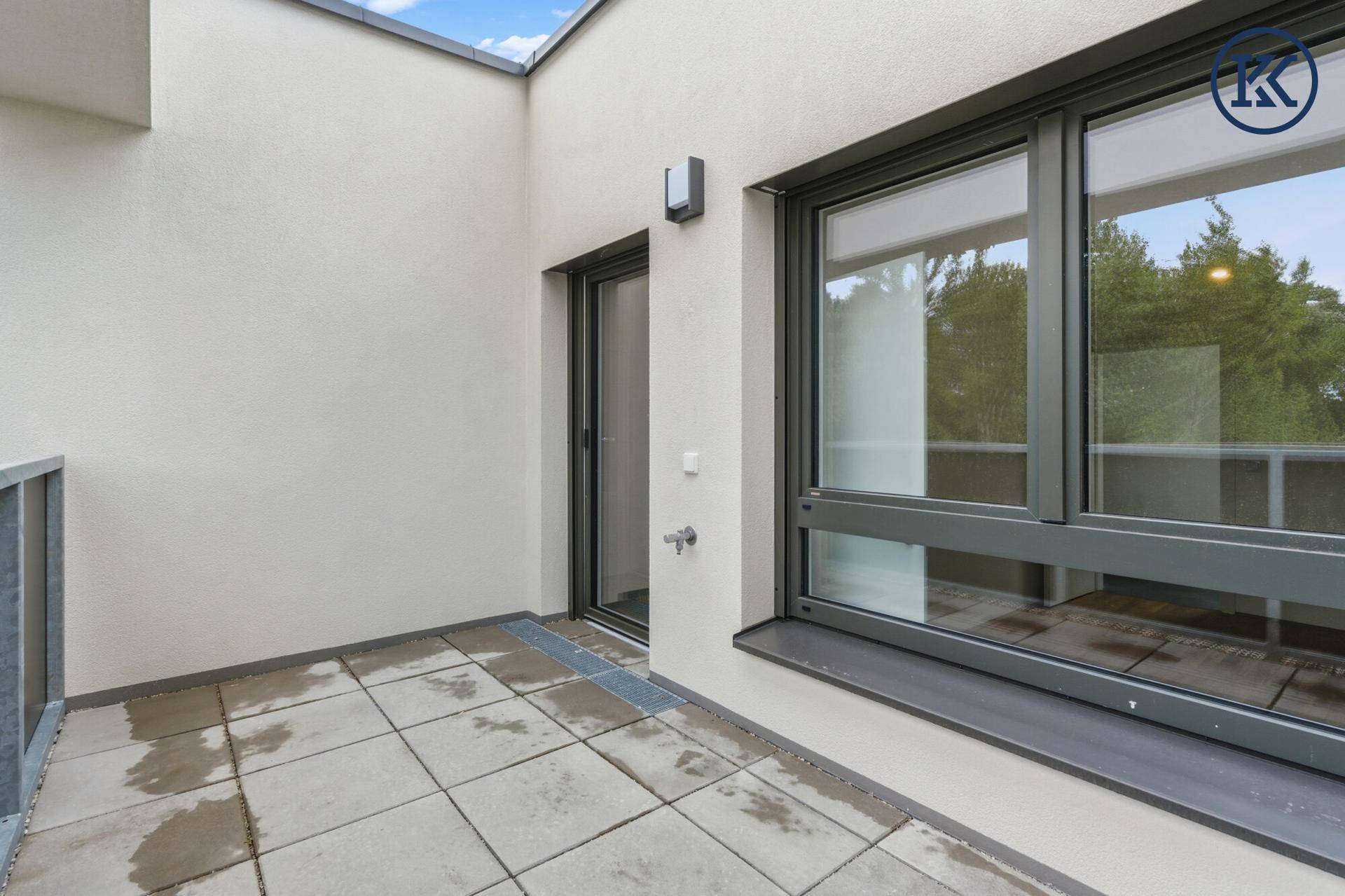 Kleiner Balkon mit Fliesenboden und moderner Brüstung, ideal für Entspannung.