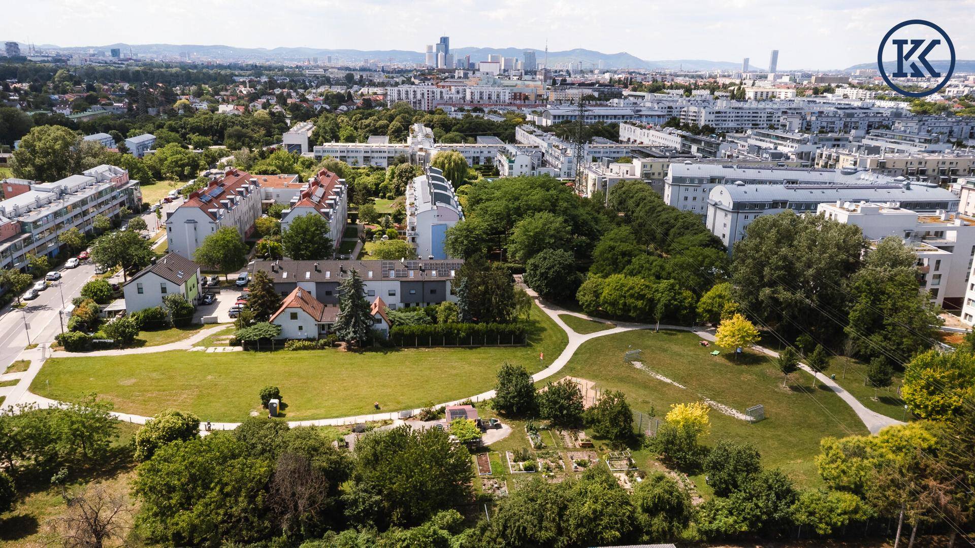 Weitläufige Luftaufnahme der Wohngegend mit viel Grün und Stadtblick.