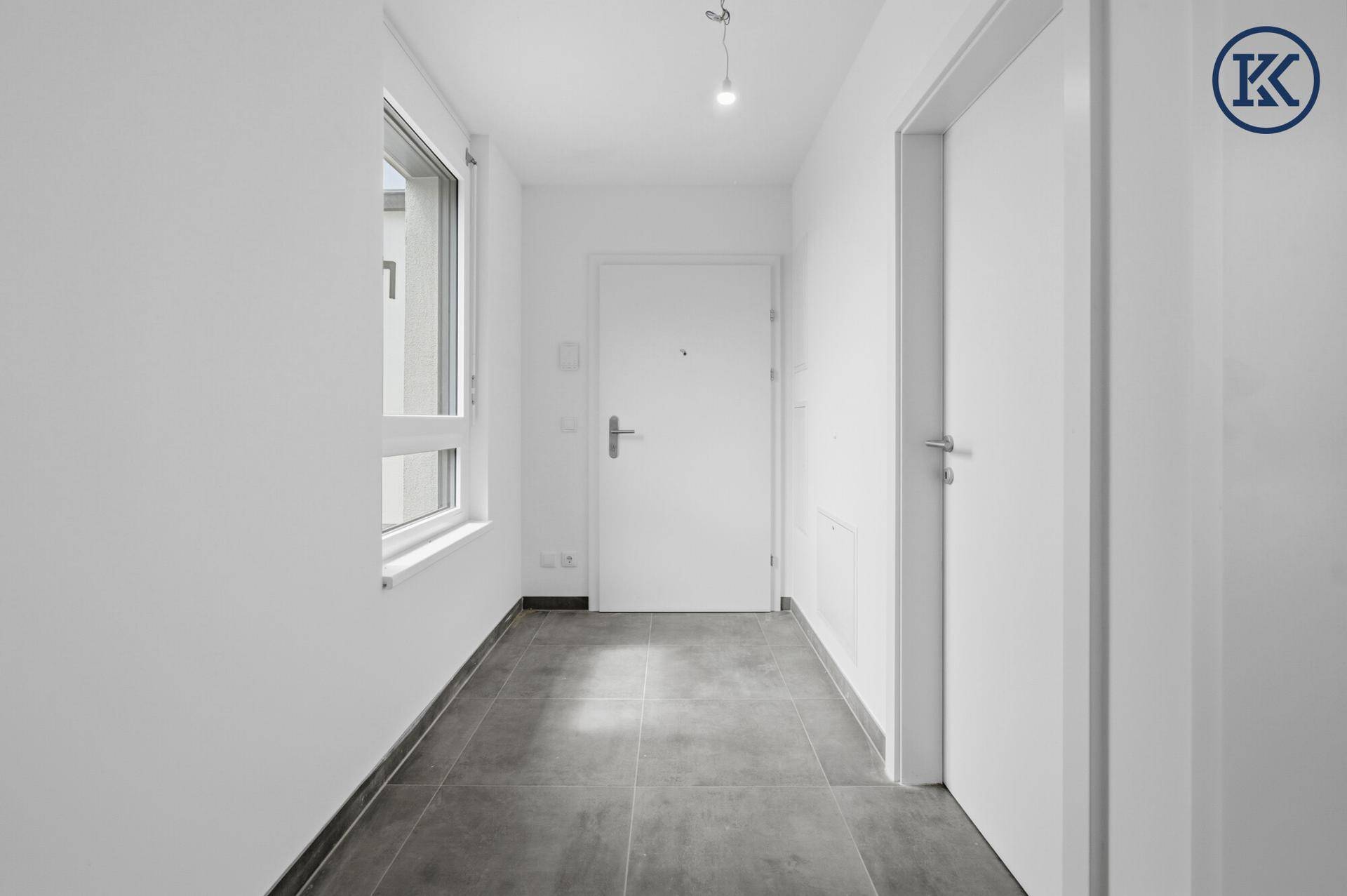 Heller Eingangsbereich einer Wohnung mit Fliesenboden und Fenster.