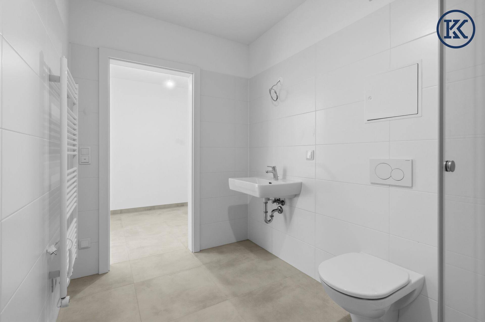 Modernes Badezimmer mit Wand-WC, Waschbecken und Handtuchheizkörper.