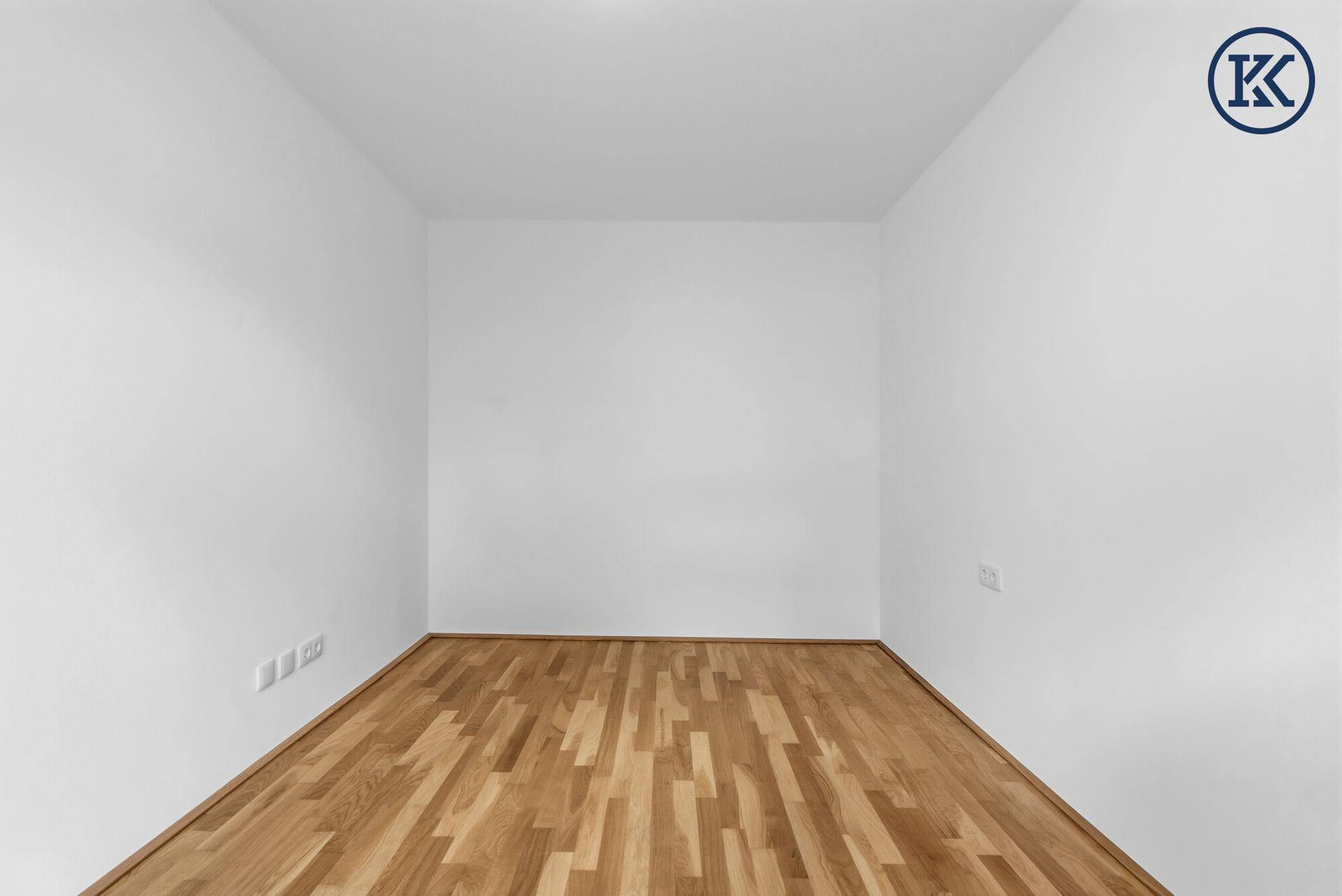 Leeres Schlafzimmer mit Parkettboden und weißen Wänden.