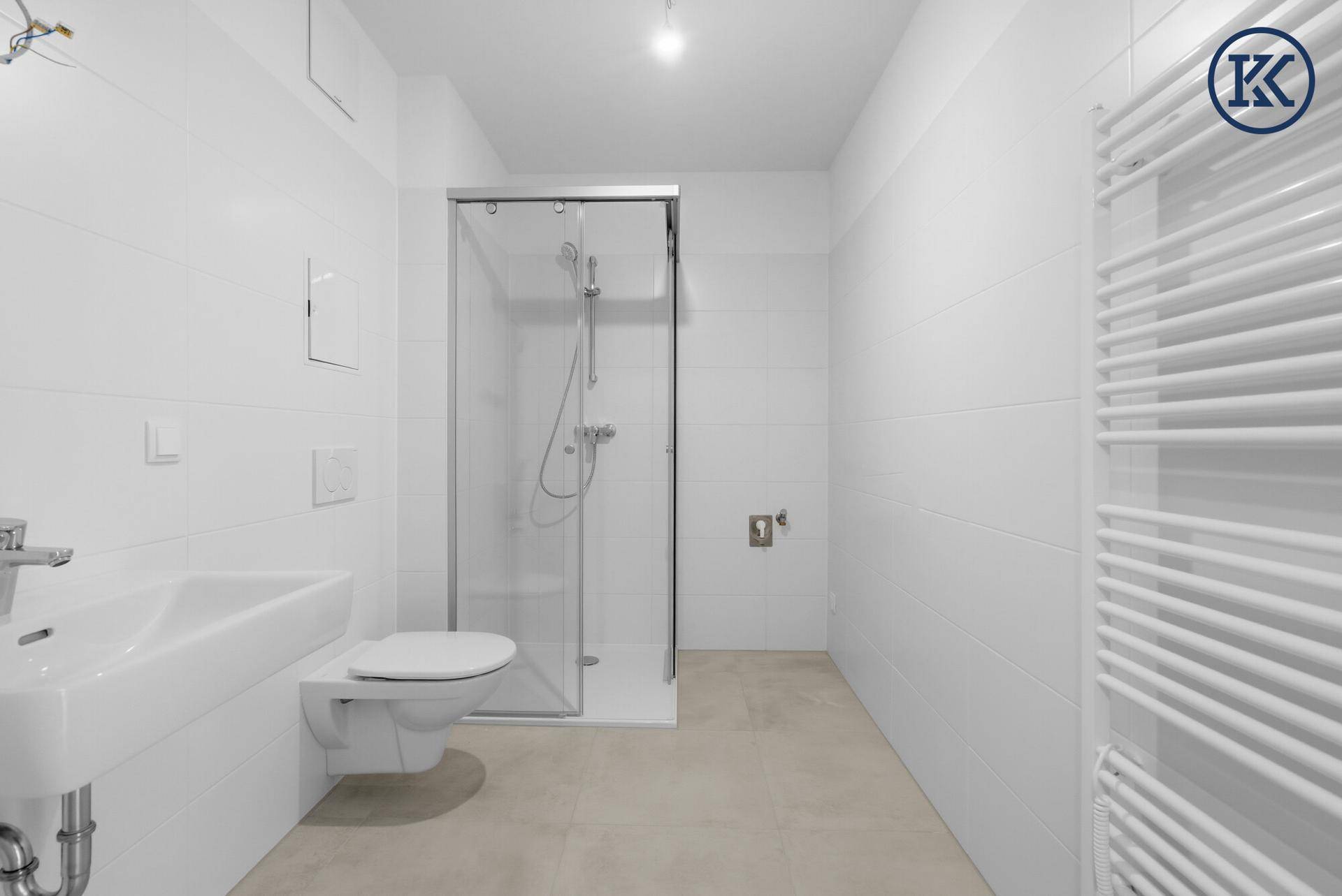 Helles Badezimmer mit Dusche, Wand-WC und Waschbecken.