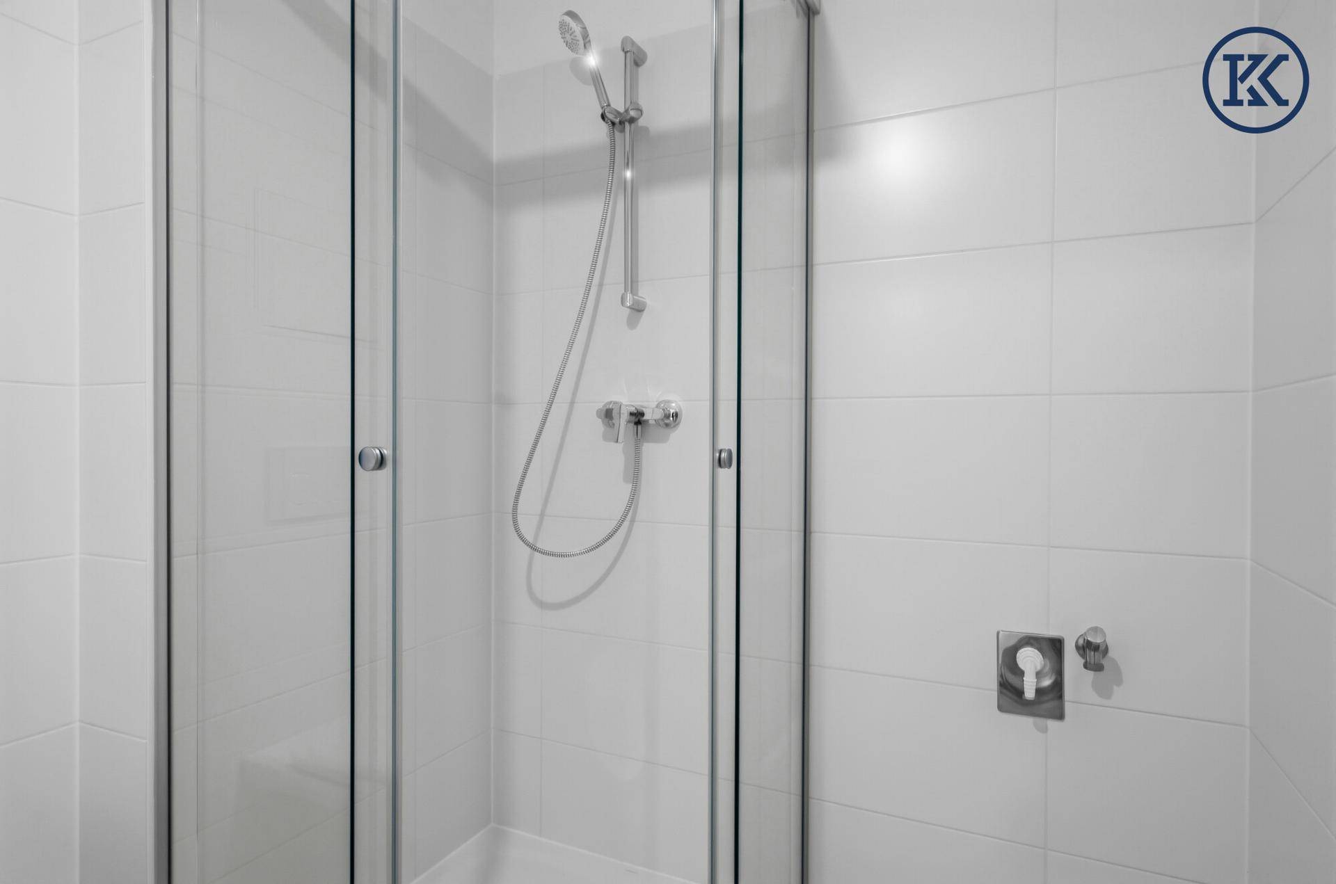Duschkabine mit Glaswänden und moderner Armatur im Badezimmer.