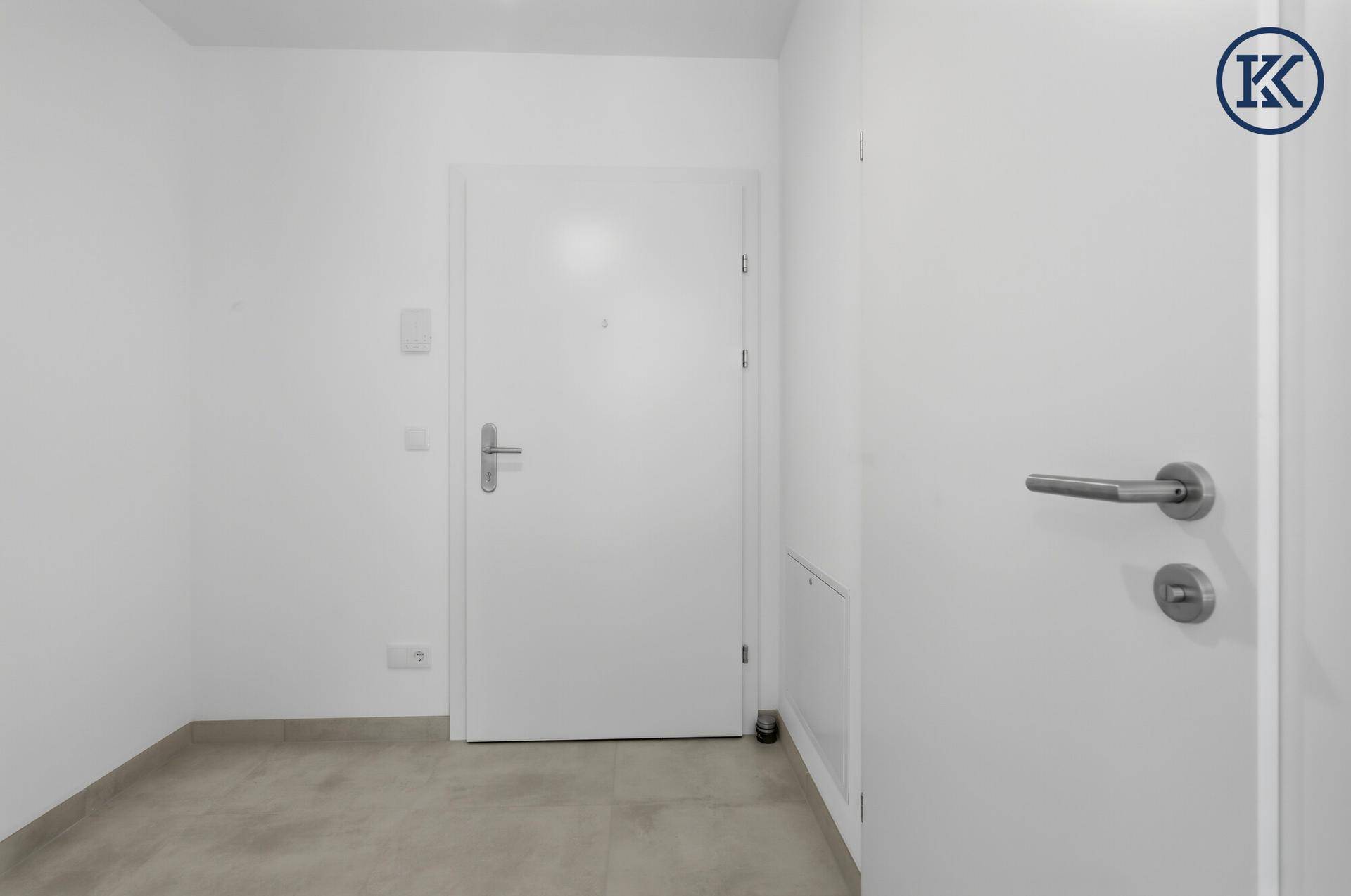 Heller Eingangsbereich mit Fliesenboden und weißen Türen.