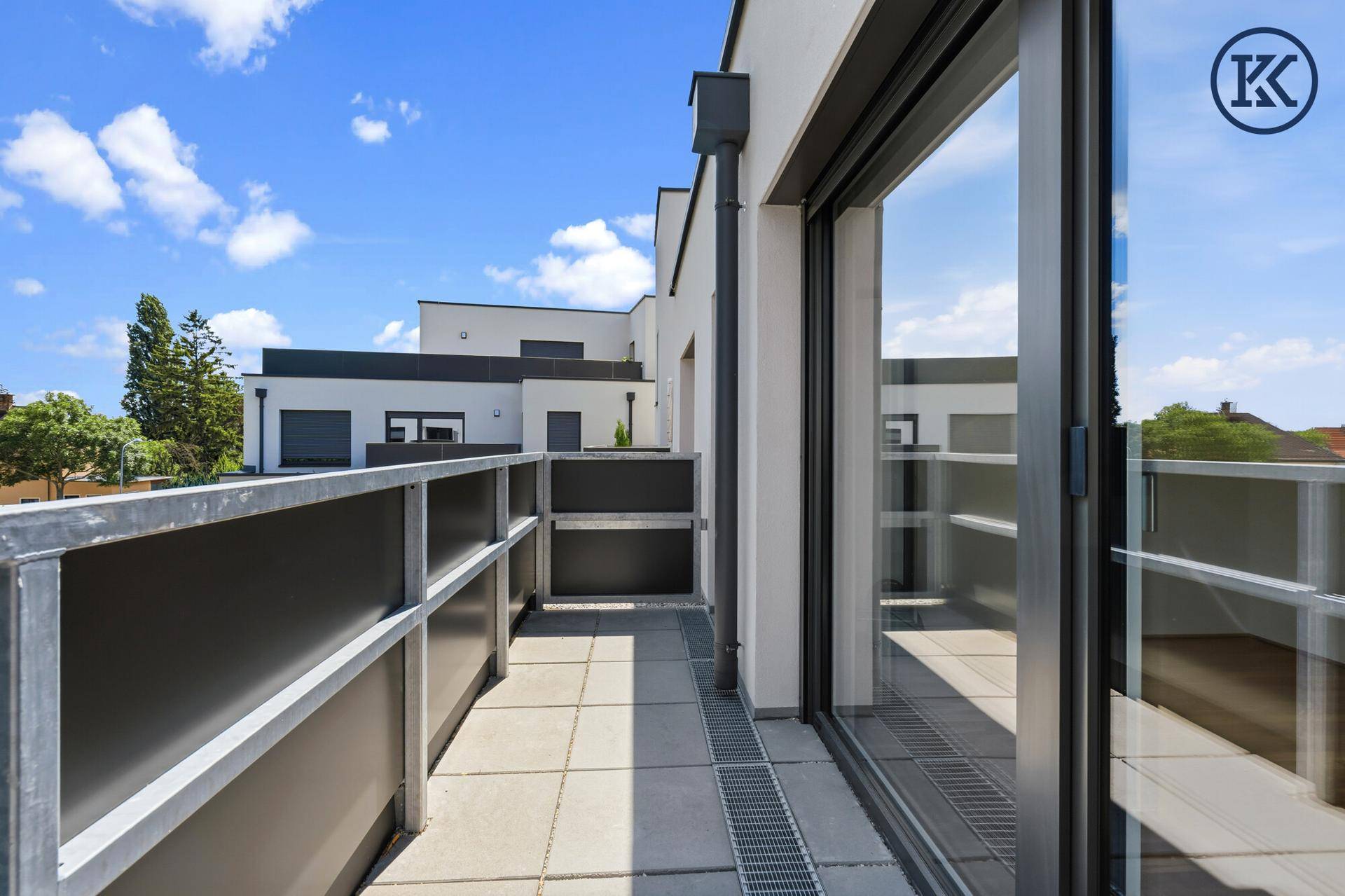 Geräumiger Balkon mit Fliesenboden und moderner Brüstung.