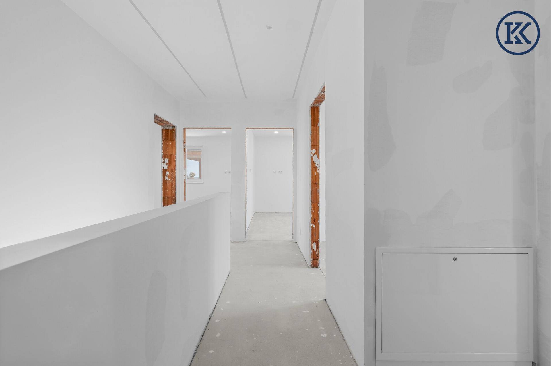 Heller Flur im Neubau mit Zugang zu mehreren Räumen und moderner Deckenbeleuchtung.