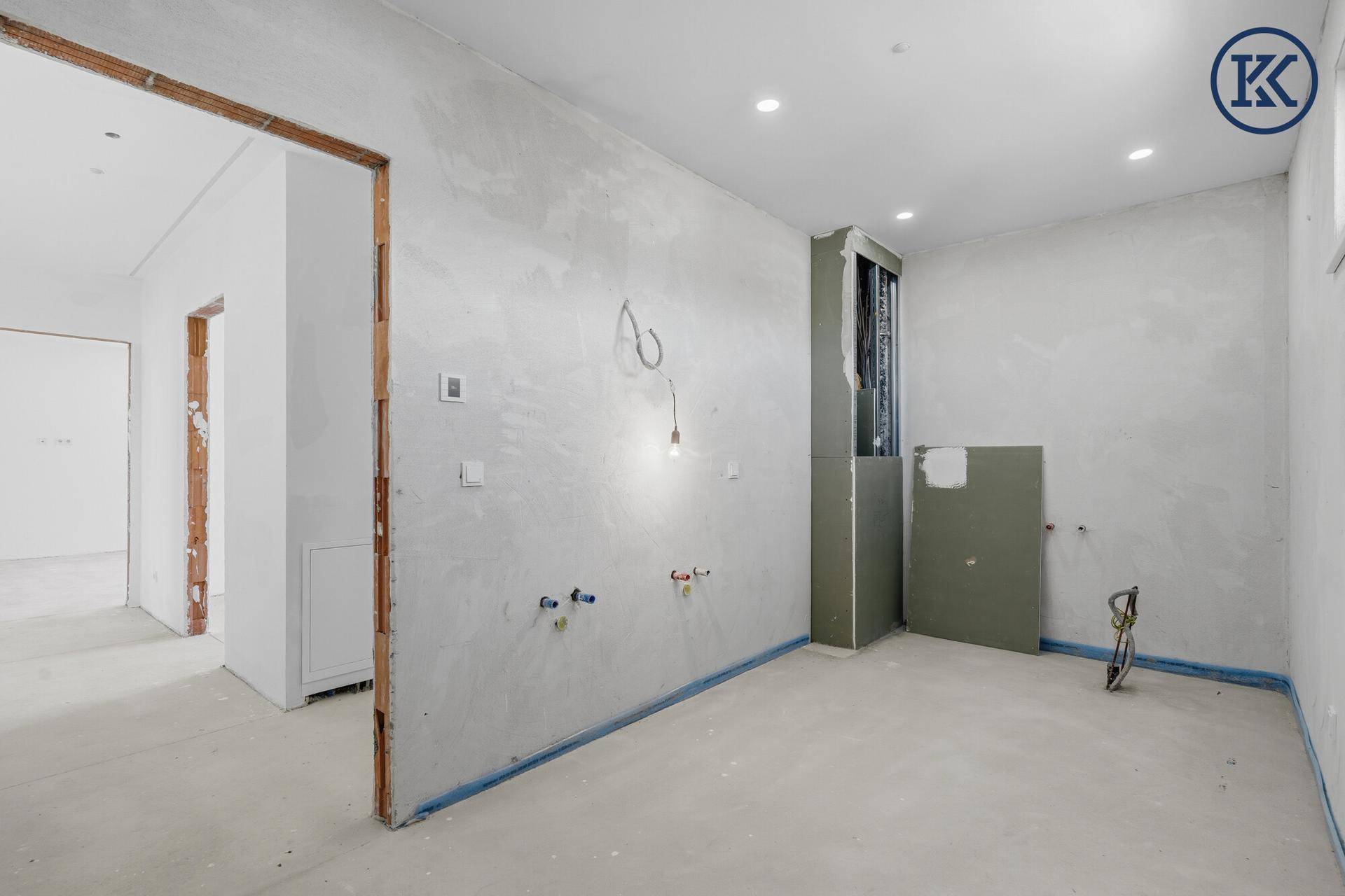 Innenraum im Rohbau mit sichtbaren Installationen und Türöffnungen, bereit für den weiteren Ausbau.